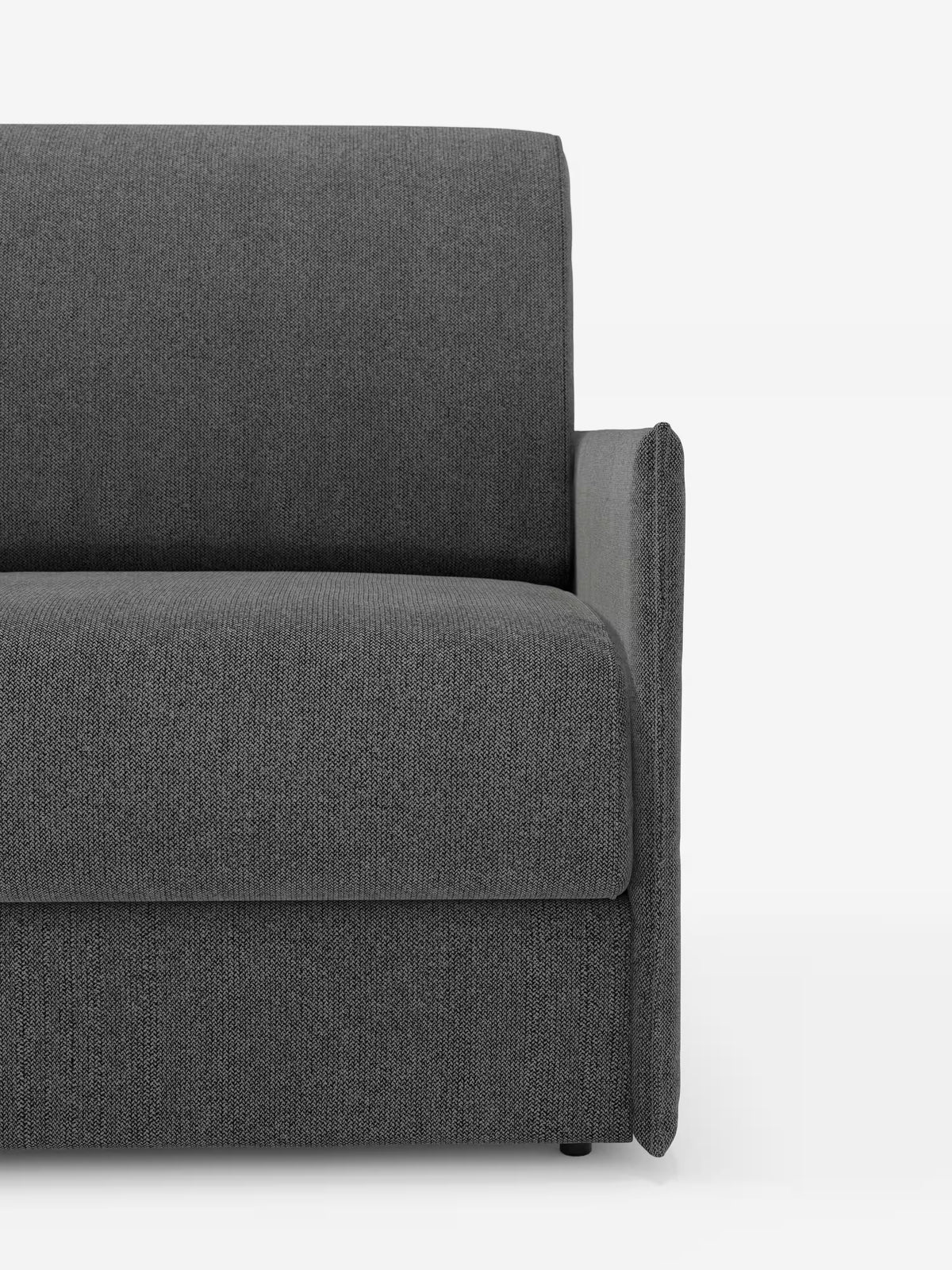 Un primo piano del lato destro della poltrona letto compatta Evans con materasso di Divani.Store ne mette in risalto il design moderno dalle linee semplici e pulite. Questa poltrona grigio scuro è dotata di un unico bracciolo destro, una seduta imbottita e uno schienale dritto, il tutto rivestito in tessuto T23 testurizzato, sfoderabile e resistente alle macchie. Ideale come soluzione salvaspazio, questo complemento d’arredo funge anche da elegante poltrona letto singola, garantendo una maggiore