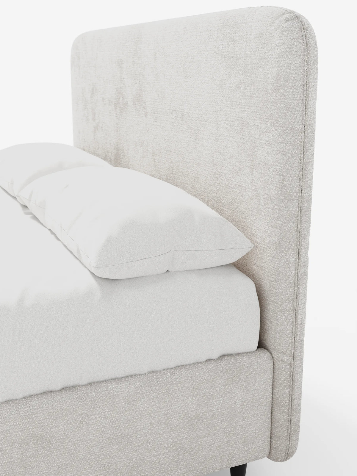 Un primo piano del letto KAELOS minimal imbottito - con contenitore, gambe alte e testiera arrotondata in tessuto ciniglia, caratterizzato da una struttura imbottita di colore beige chiaro con testiera arrotondata, con biancheria da letto bianca su gambe sottili e scure su uno sfondo bianco.