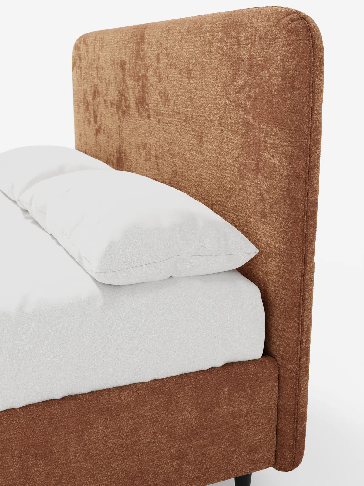 Un primo piano del letto KAELOS minimal imbottito in ciniglia color ruggine, con testiera arrotondata, rivestito con lenzuola bianchissime per un look raffinato nella camera da letto.