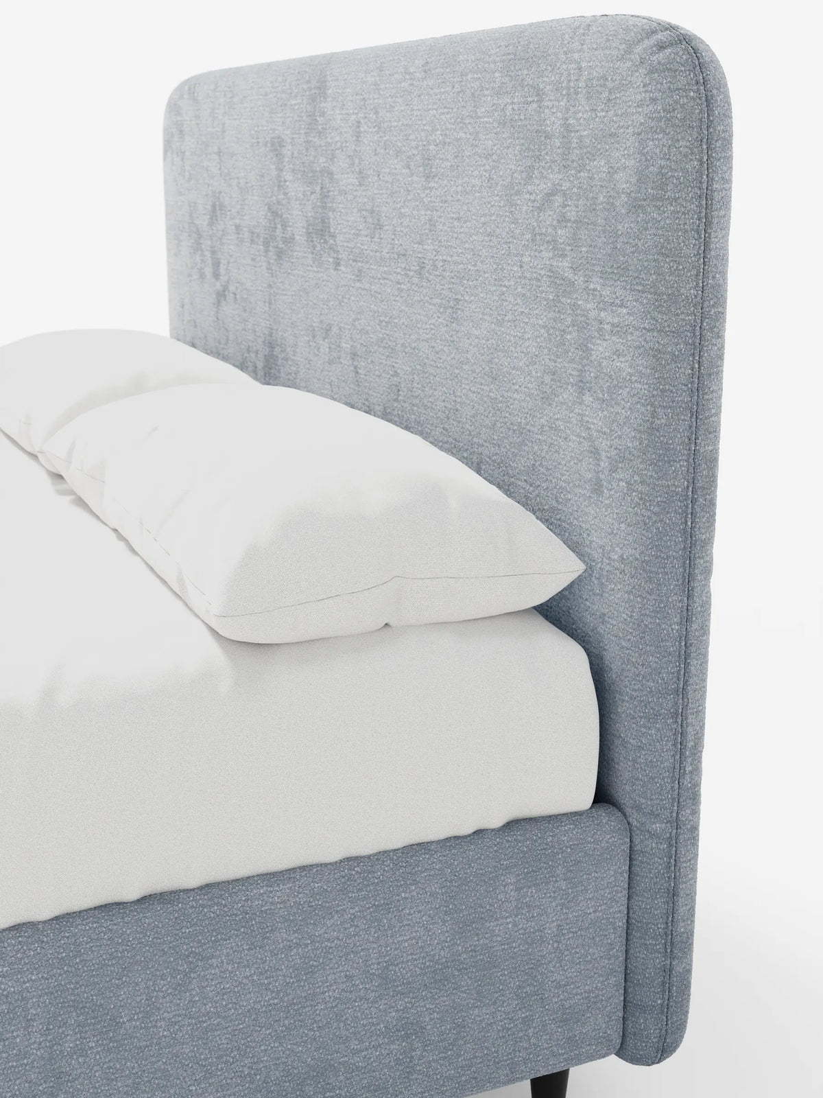 Il letto imbottito KAELOS Letto Minimal presenta una testiera alta e arrotondata in tessuto grigio testurizzato, lenzuola bianche immacolate e gambe sottili e scure che risaltano su uno sfondo bianco a tinta unita, rendendolo ideale per una camera da letto moderna.