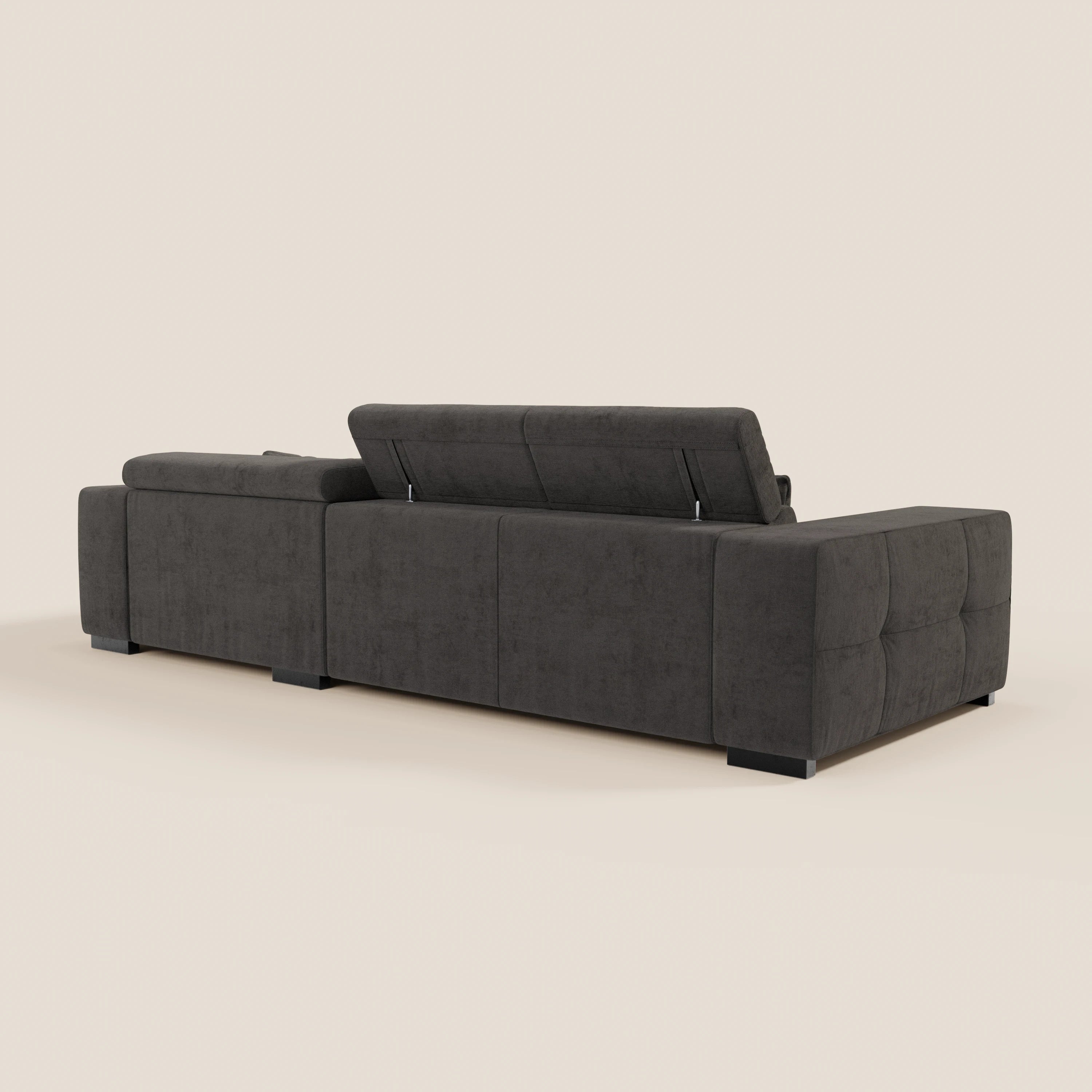 Il Monarch Divano angolare con penisola e Relax Elettrico di Divani.Store, in tessuto smacchiabile T31 grigio scuro, è caratterizzato da ampi braccioli, poggiatesta reclinabile e gambe corte a blocco, mostrate dal retro su sfondo beige chiaro.