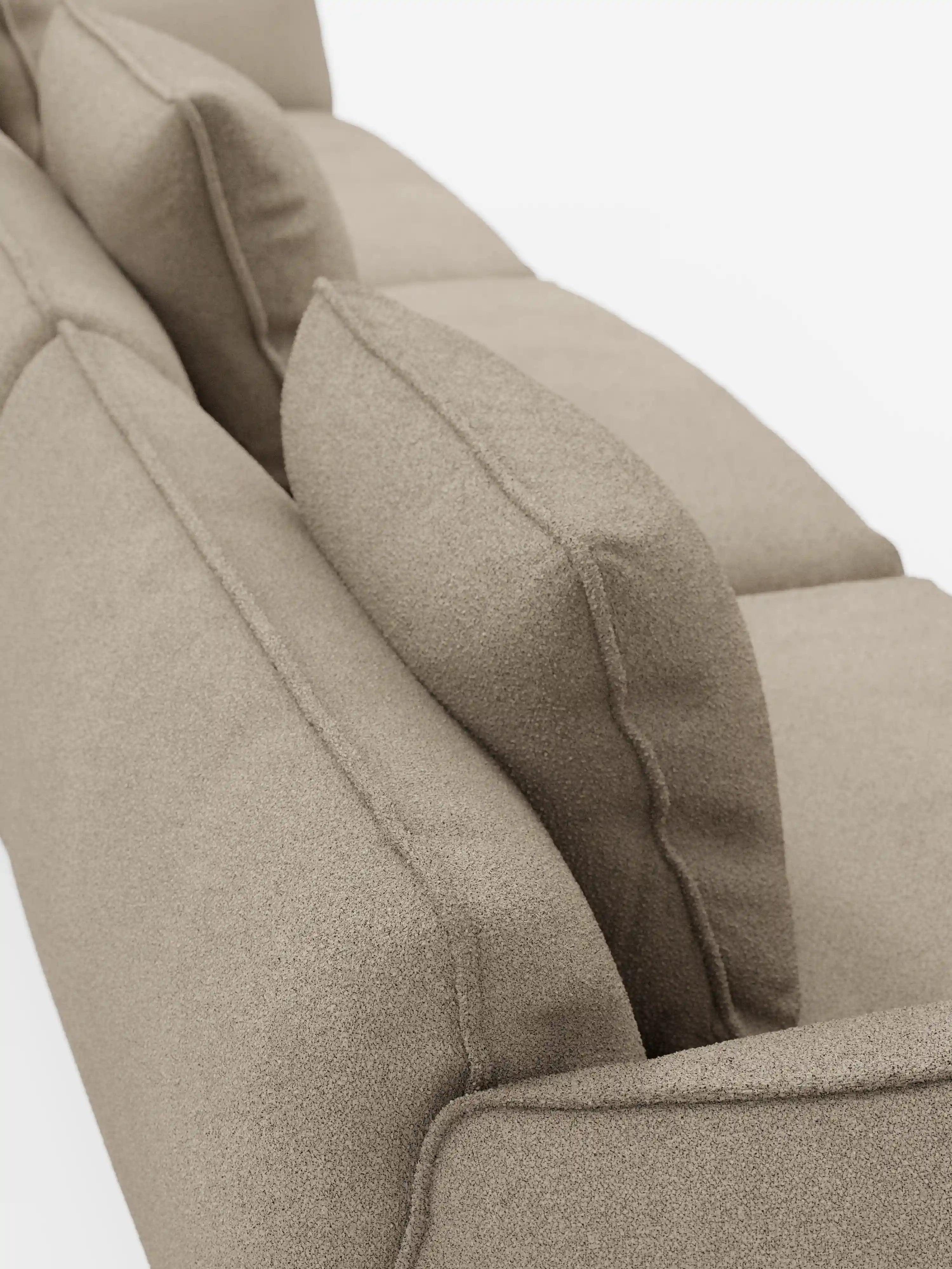 Primo piano del divano modulare a 3 posti Nimbus di Divani.Store, rivestito in morbido tessuto smacchiabile beige effetto cotone T33. L’immagine mette in risalto il tessuto testurizzato, le cuciture precise e i cuscini dello schienale ben dritti su uno sfondo bianco a tinta unita, evidenziando l’imbottitura soffice e le curve delicate del divano.