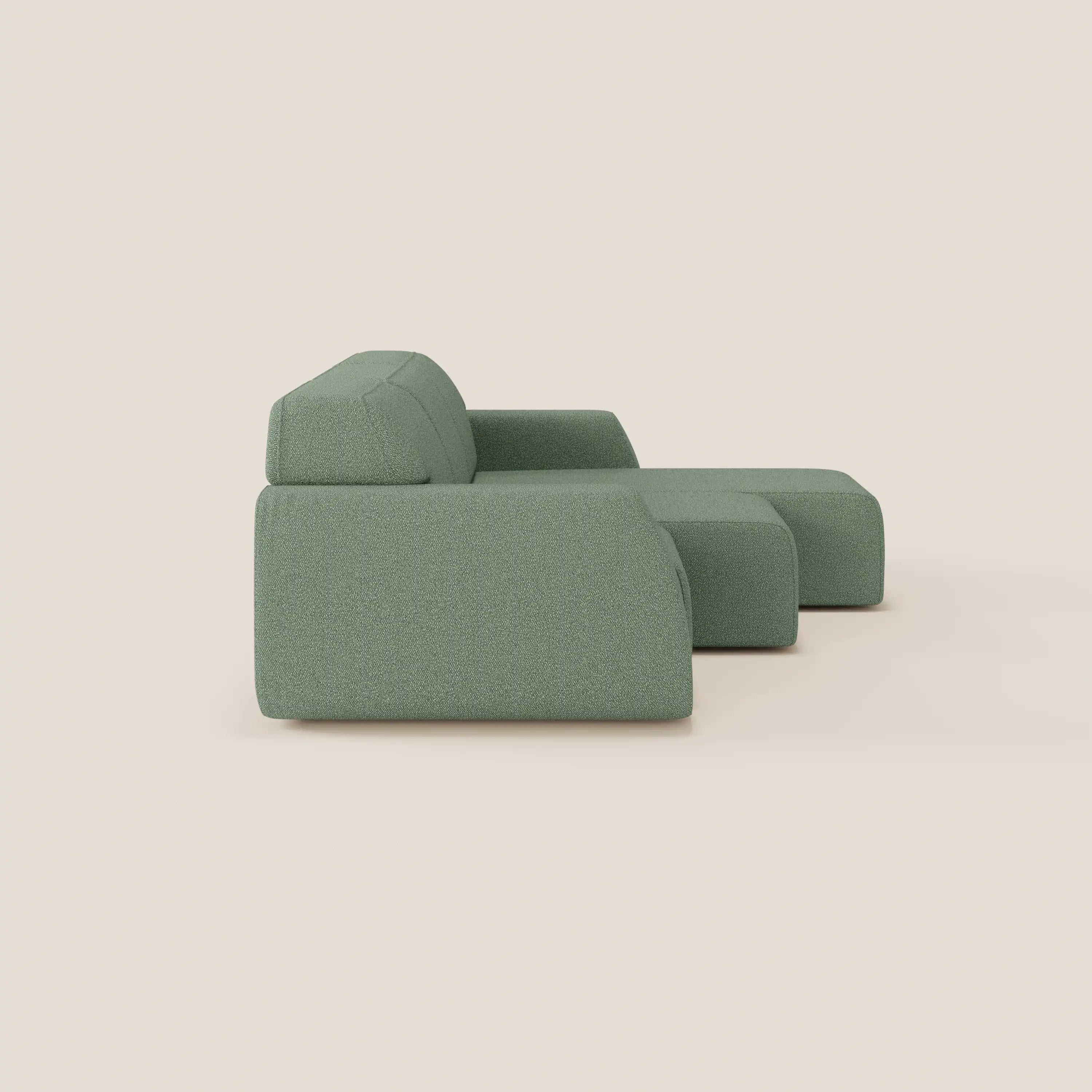 Il Divano angolare Orbit di Divani.Store è caratterizzato da un design moderno di colore verde con chaise reversibile, sedute allungabili e tessuto antimacchia effetto cotone, che aggiunge un tocco accogliente sullo sfondo beige chiaro.