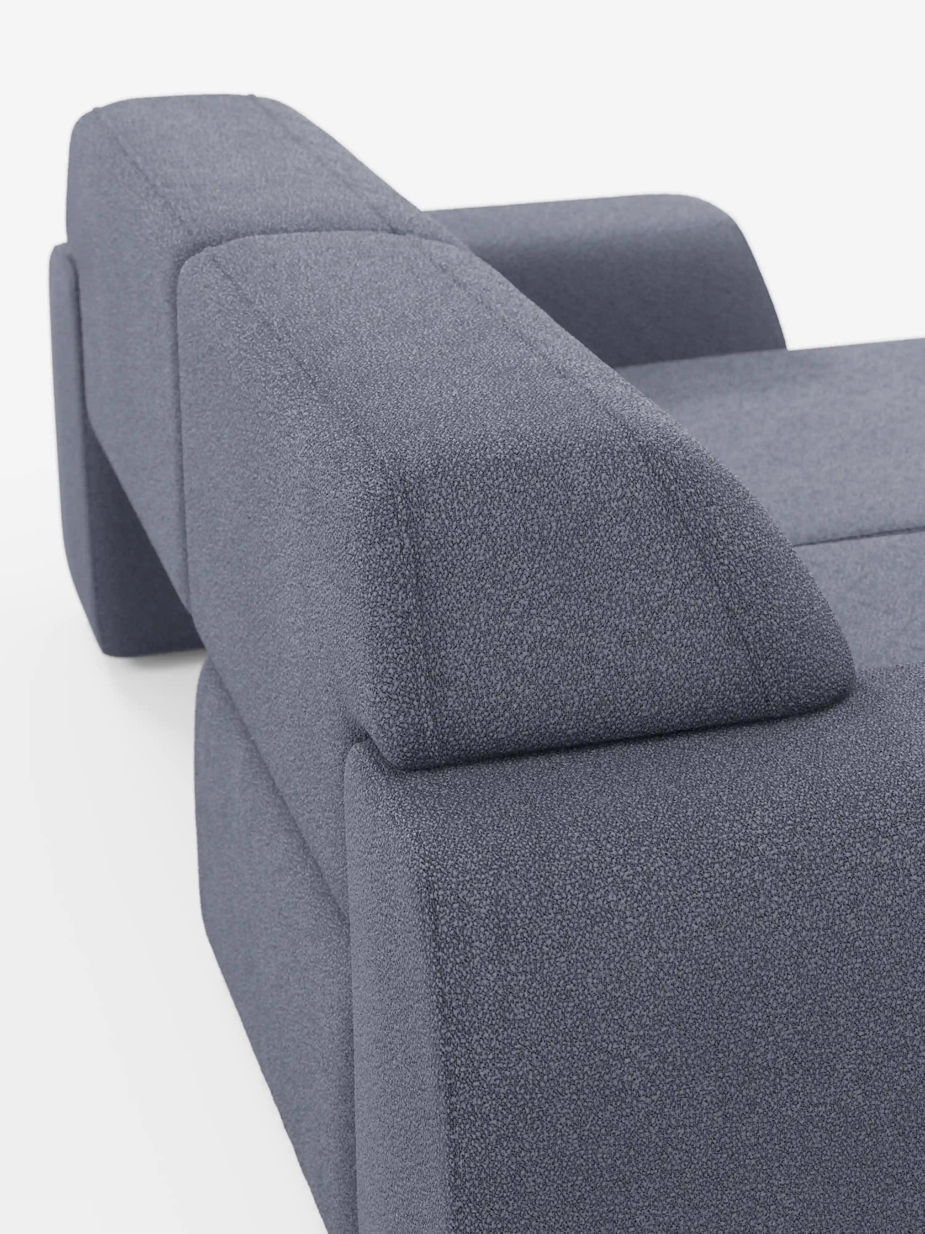 Un primo piano del divano Orbit a 2 e 3 posti di Divani.Store ne mette in risalto il moderno rivestimento blu-grigio in tessuto smacchiabile effetto cotone T33. L’immagine mette in risalto i braccioli spessi e spigolosi e lo schienale slanciato, caratterizzato da linee pulite e geometriche e da un design minimalista su sfondo bianco, cogliendo perfettamente l’eleganza di questo divano completamente sfoderabile con sedute scorrevoli, che garantiscono maggiore comfort e versatilità.