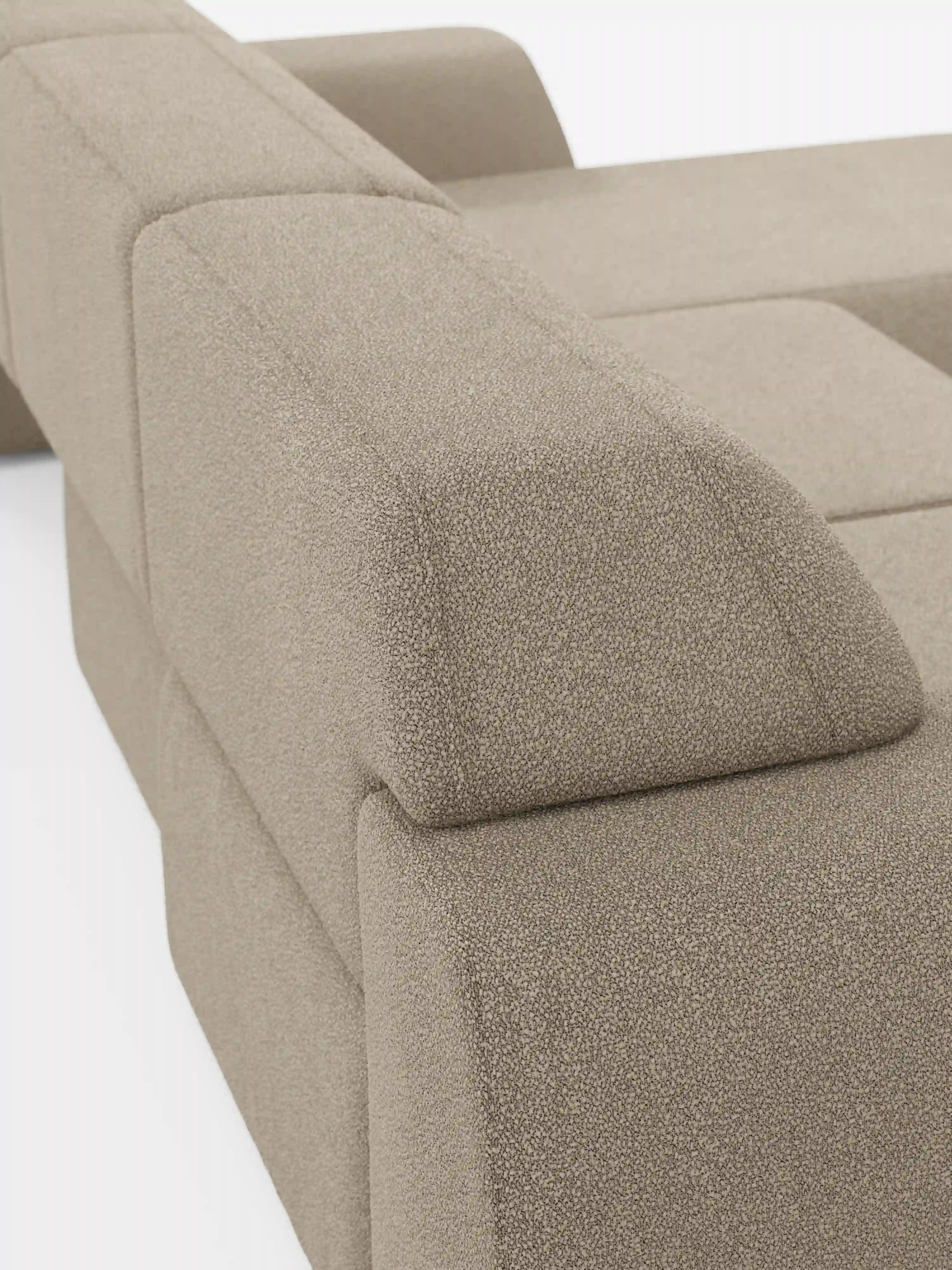 Un primo piano del divano angolare Orbit con penisola reversibile e tutte le sedute allungabili, rivestito in tessuto smacchiabile effetto cotone T33 di Divani.Store, mette in risalto il design moderno e geometrico dei braccioli e della seduta. Il tessuto beige, effetto cotone e resistente alle macchie, presenta una finitura morbida ma dalla trama delicatamente ruvida. Le linee pulite e lo stile minimalista risaltano sullo sfondo di un bianco brillante.