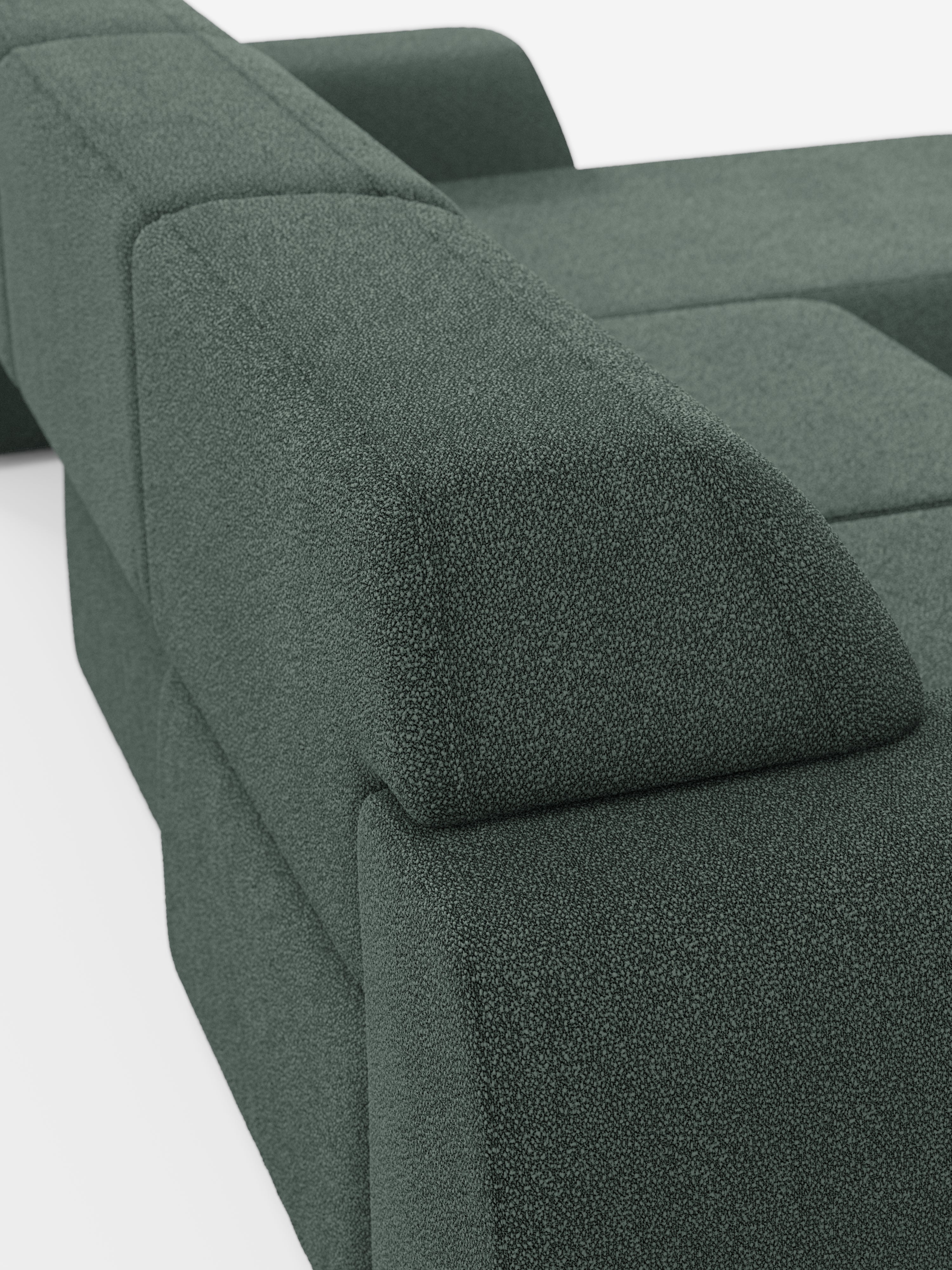 Primo piano del divano angolare Orbit con penisola reversibile e tutte le sedute allungabili di Divani.Store, rivestito in tessuto smacchiabile effetto cotone T33 di colore verde scuro. Questo divano componibile presenta ampi braccioli angolari, cuscini di seduta profondi e una finitura in tessuto testurizzato. Caratterizzato da un design moderno dalle linee pulite e dalle superfici morbide, la sua eleganza e versatilità risaltano sullo sfondo bianco.