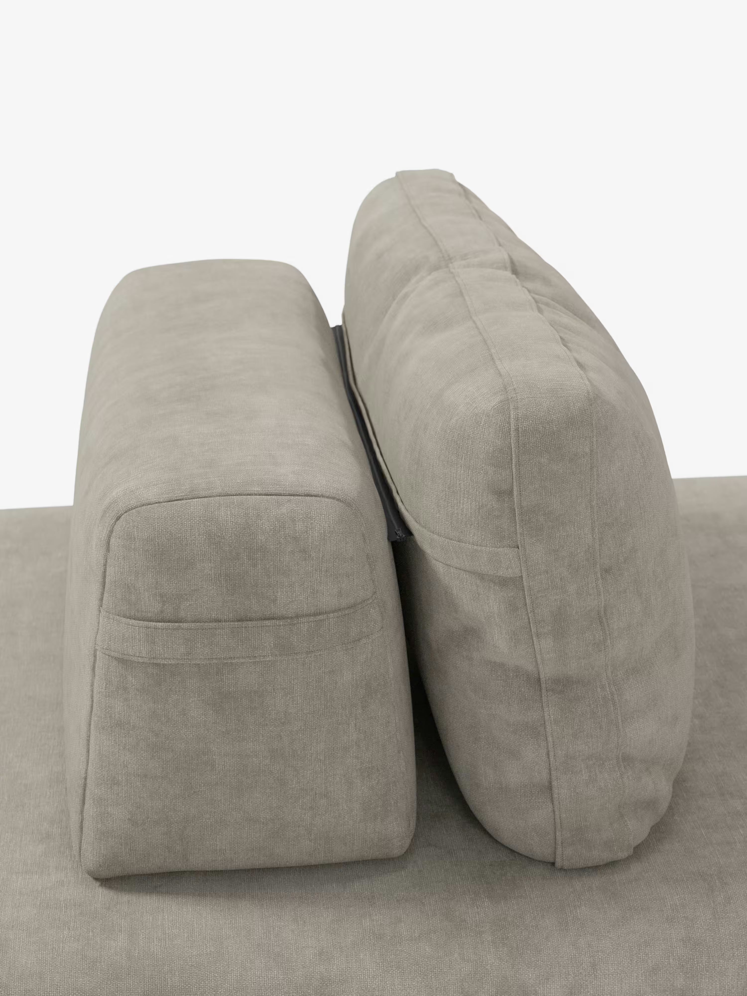 Due cuscini rettangolari di colore grigio chiaro sono disposti in posizione verticale sulla base abbinata del divano letto matrimoniale Rift a 2 e 3 posti con schienali mobili di Divani.Store. Il cuscino di sinistra è leggermente più alto e dalla forma più squadrata, mentre quello di destra, dotato di schienale mobile, presenta un aspetto più arrotondato e morbido. Lo sfondo è bianco a tinta unita.