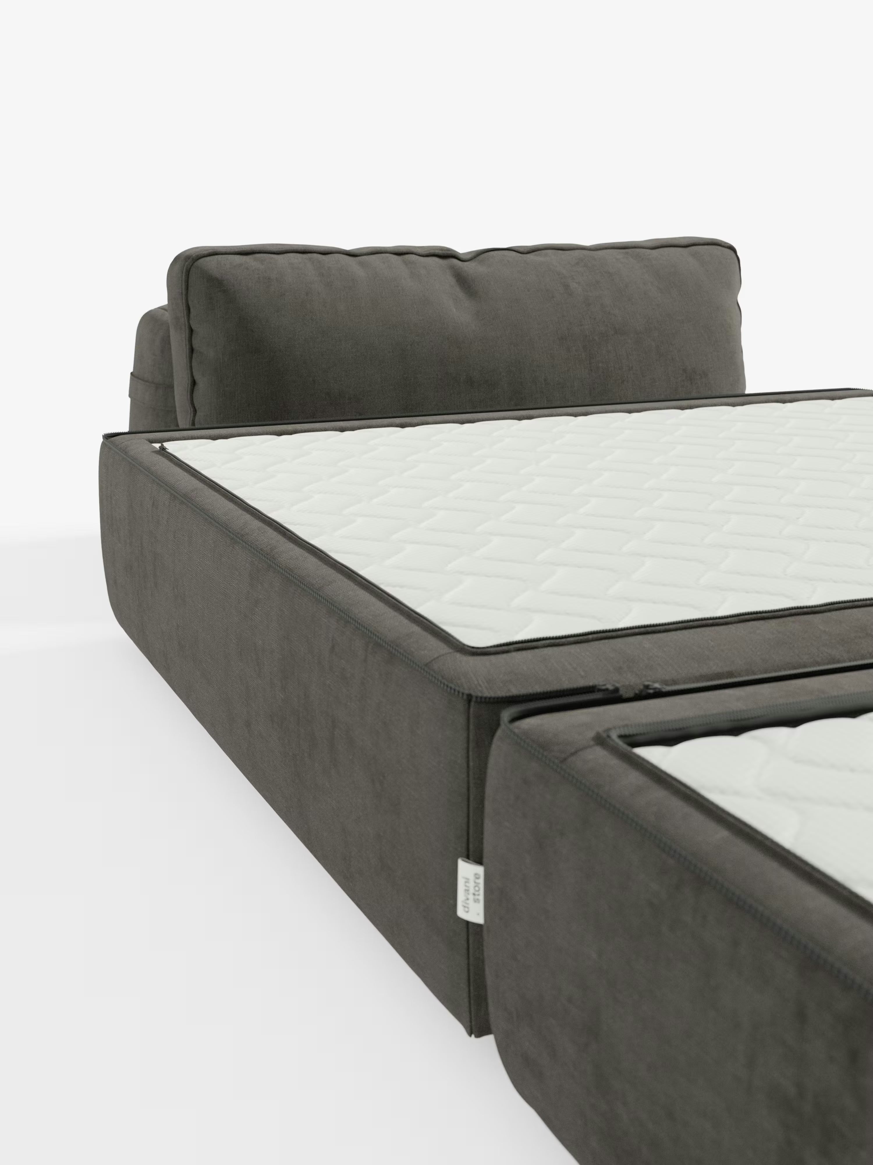 Viene mostrata una poltrona letto Rift di colore grigio scuro di Divani.Store, con il suo materasso in memory foam bianco alto 24 cm, parzialmente aperto per evidenziare il netto passaggio da divano a letto. Lo schienale mobile e il morbido tessuto T31 antimacchia risaltano su uno sfondo bianco a tinta unita, con una piccola etichetta in tessuto fissata sul lato.