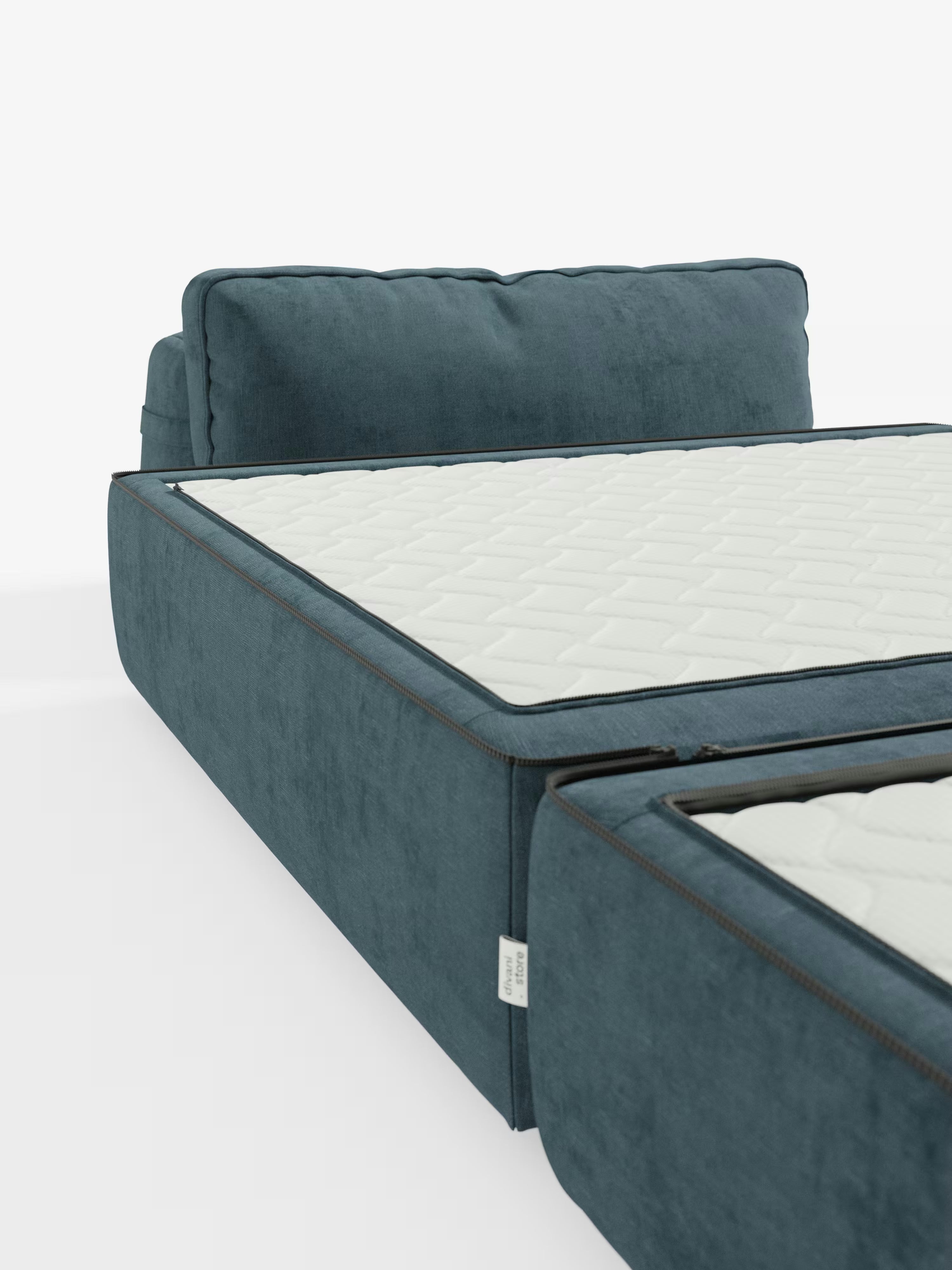Un primo piano del divano letto Rift con materasso alto 24 cm e memory foam di Divani.Store, rivestito in moderno tessuto blu smacchiabile T31, mostra il divano letto parzialmente aperto, rivelando il suo materasso bianco trapuntato con cerniera. Questo modello è caratterizzato da uno schienale mobile, morbidi cuscini profondi ed è presentato su uno sfondo bianco.