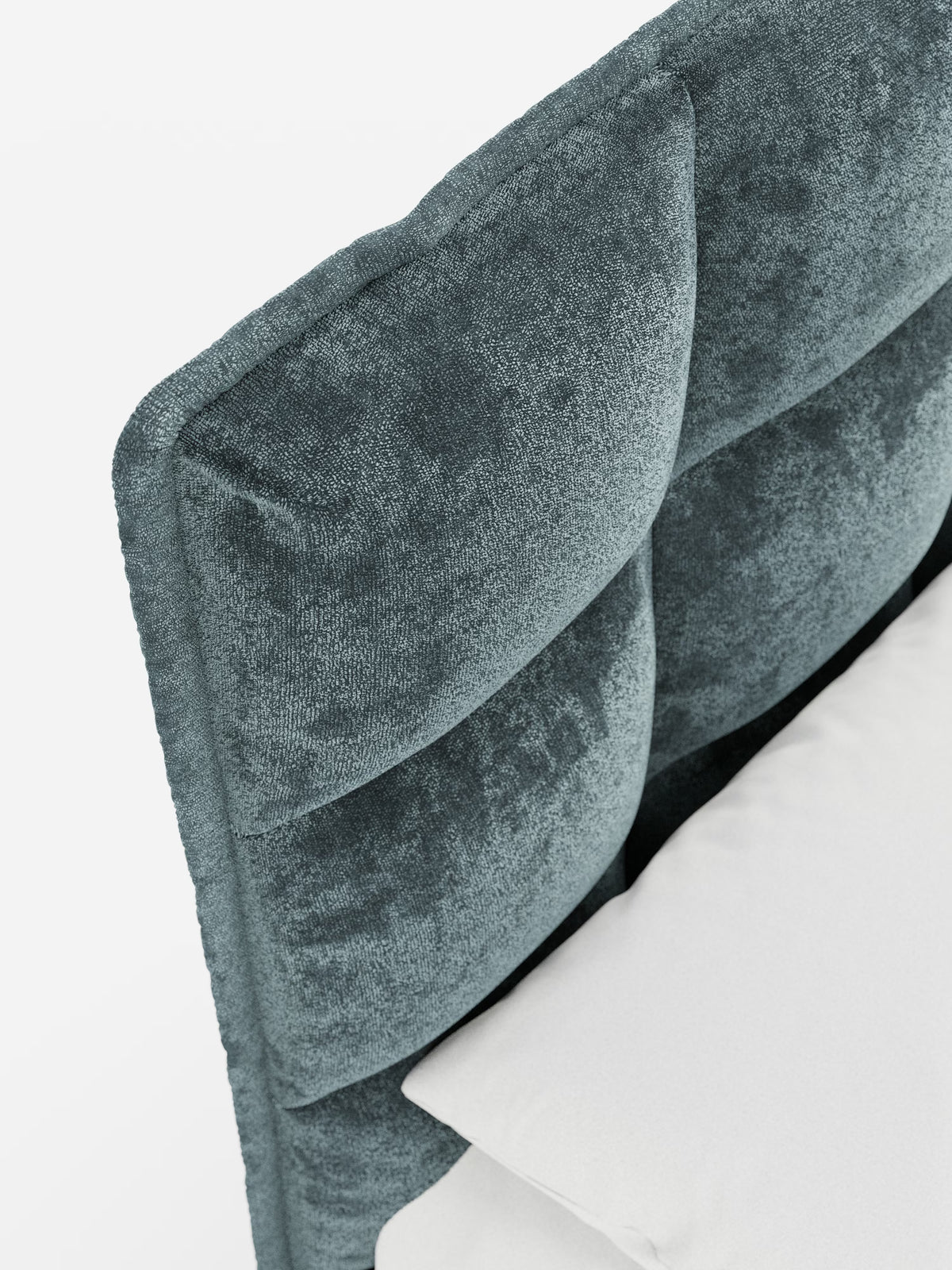 Primo piano del letto imbottito AURO con contenitore e testiera capitonné alta in ciniglia Oeko-Tex® di Letti.store. L’immagine mette in risalto la testiera in ciniglia color verde acqua scuro, dalla trama rigata, con un’elegante trapuntatura orizzontale che richiama lo stile moderno della testiera capitonné. La testiera è perfettamente integrata nella base del letto imbottito contenitore, con un cuscino bianco parzialmente visibile nella parte inferiore su uno sfondo bianco a tinta unita.
