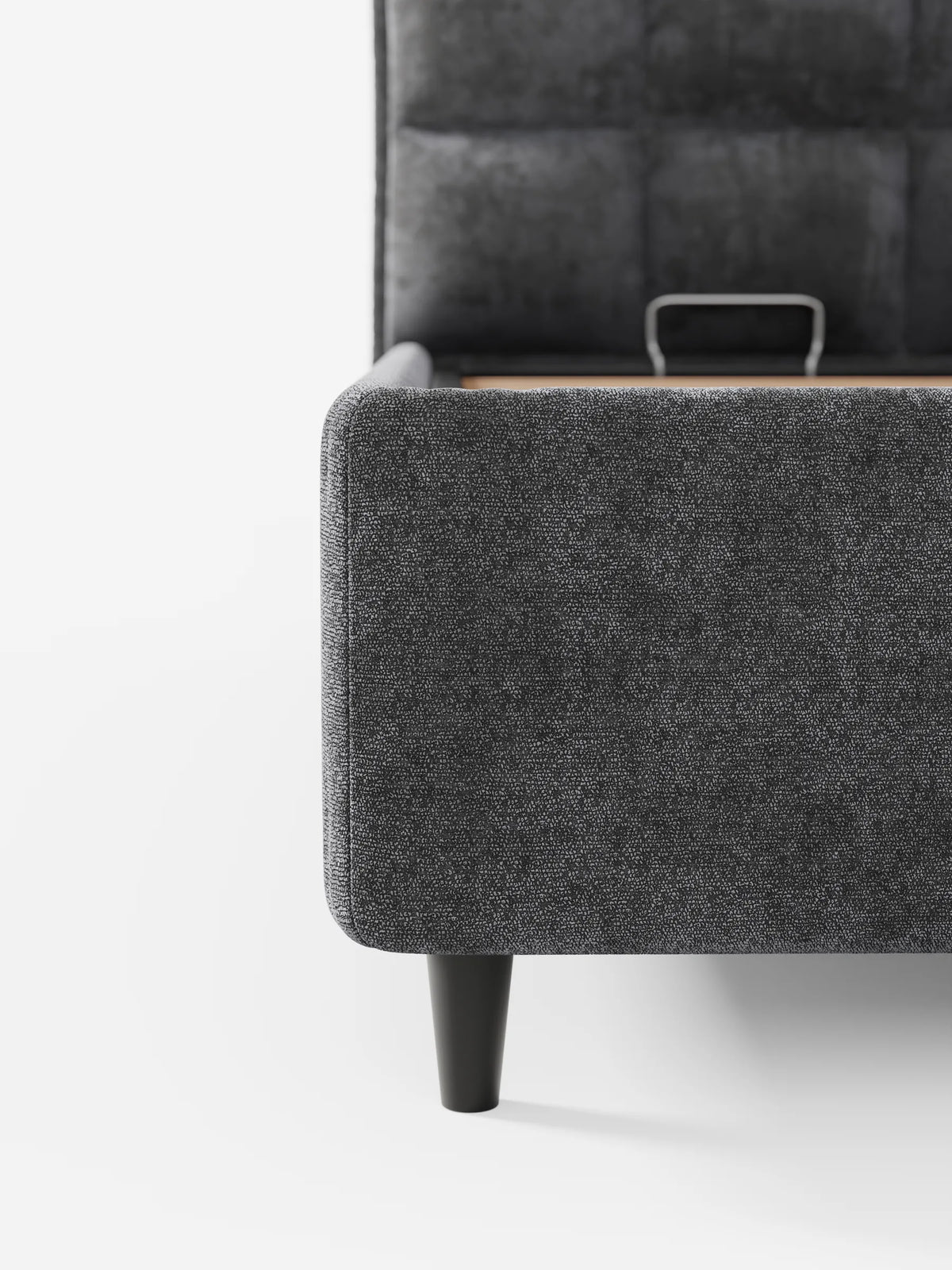 Letto imbottito AURO con contenitore e testiera alta capitonné in ciniglia Oeko-Tex® color grigio antracite, con testiera alta capitonné, gambe corte affusolate di colore scuro e meccanismo di sollevamento interno, su uno sfondo bianco a tinta unita.