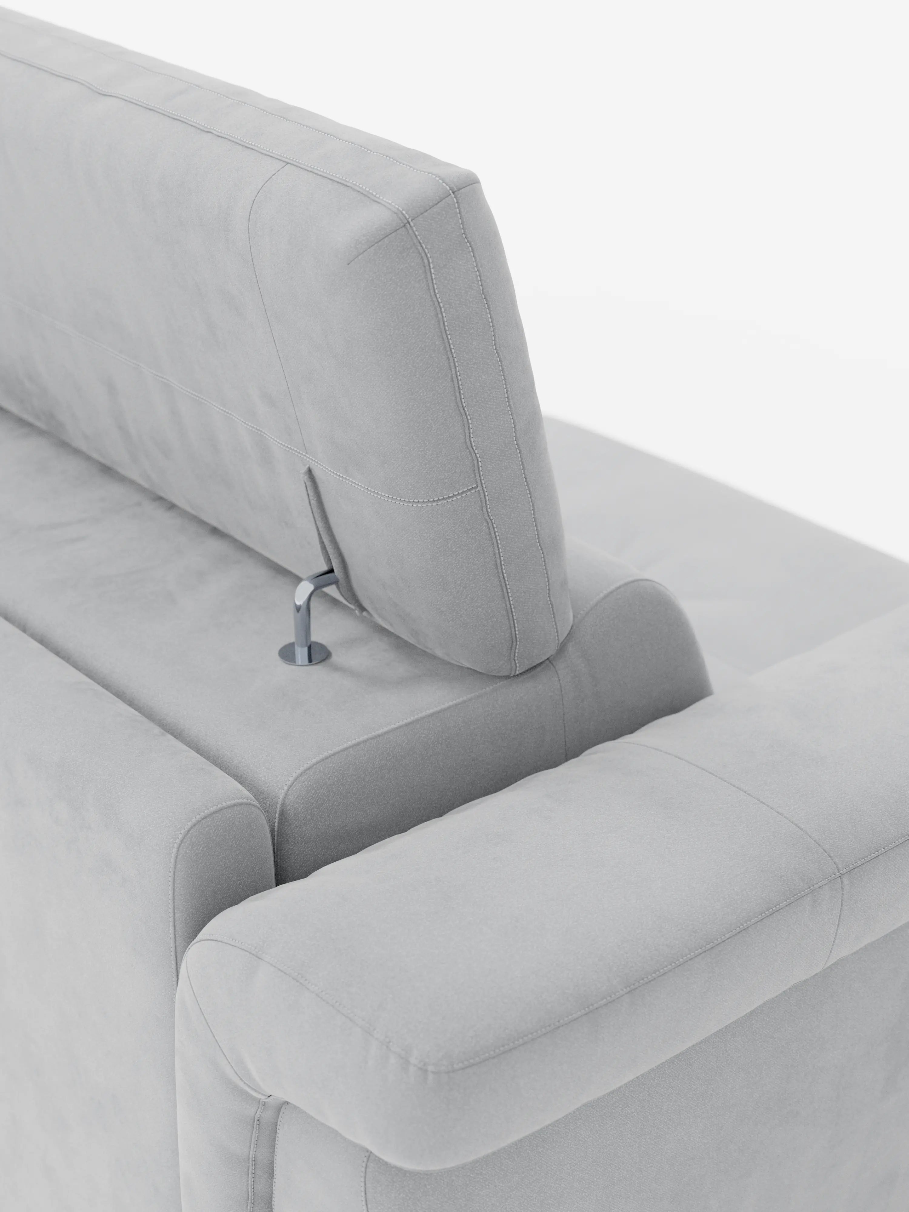 Un primo piano del divano letto di design Capri con piedini alti di Divani.Store, rivestito in raffinato tessuto T30 effetto velluto, resistente alle macchie, in grigio chiaro. L'immagine mette in risalto il poggiatesta regolabile, dotato di un elegante meccanismo di regolazione in metallo e di morbidi cuscini, il tutto presentato su uno sfondo bianco minimalista e ben illuminato per esaltarne l'artigianalità italiana.