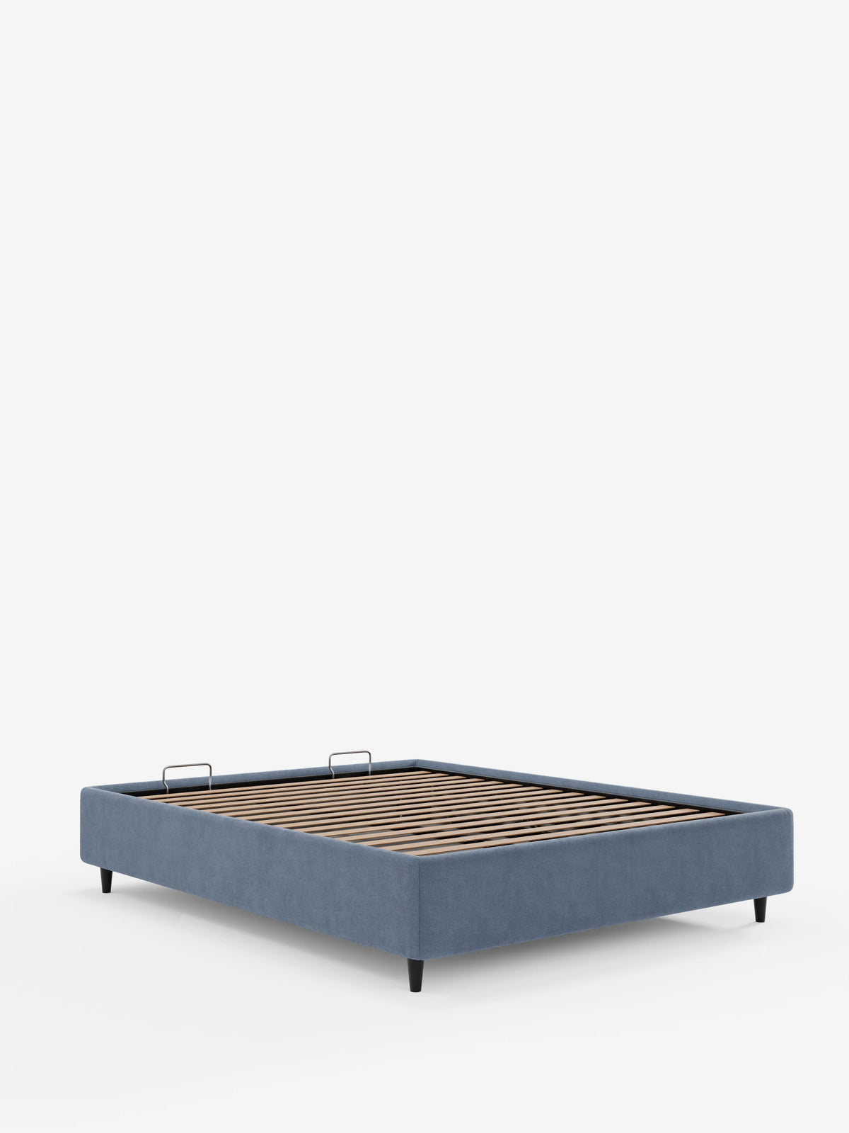 Un letto sommier imbottito ERON con contenitore, rivestito in tessuto impermeabile certificato Oeko-Tex color blu polveroso, caratterizzato da una rete a doghe in legno, due fermamaterasso argentati e quattro gambe corte e affusolate di colore scuro su sfondo bianco.