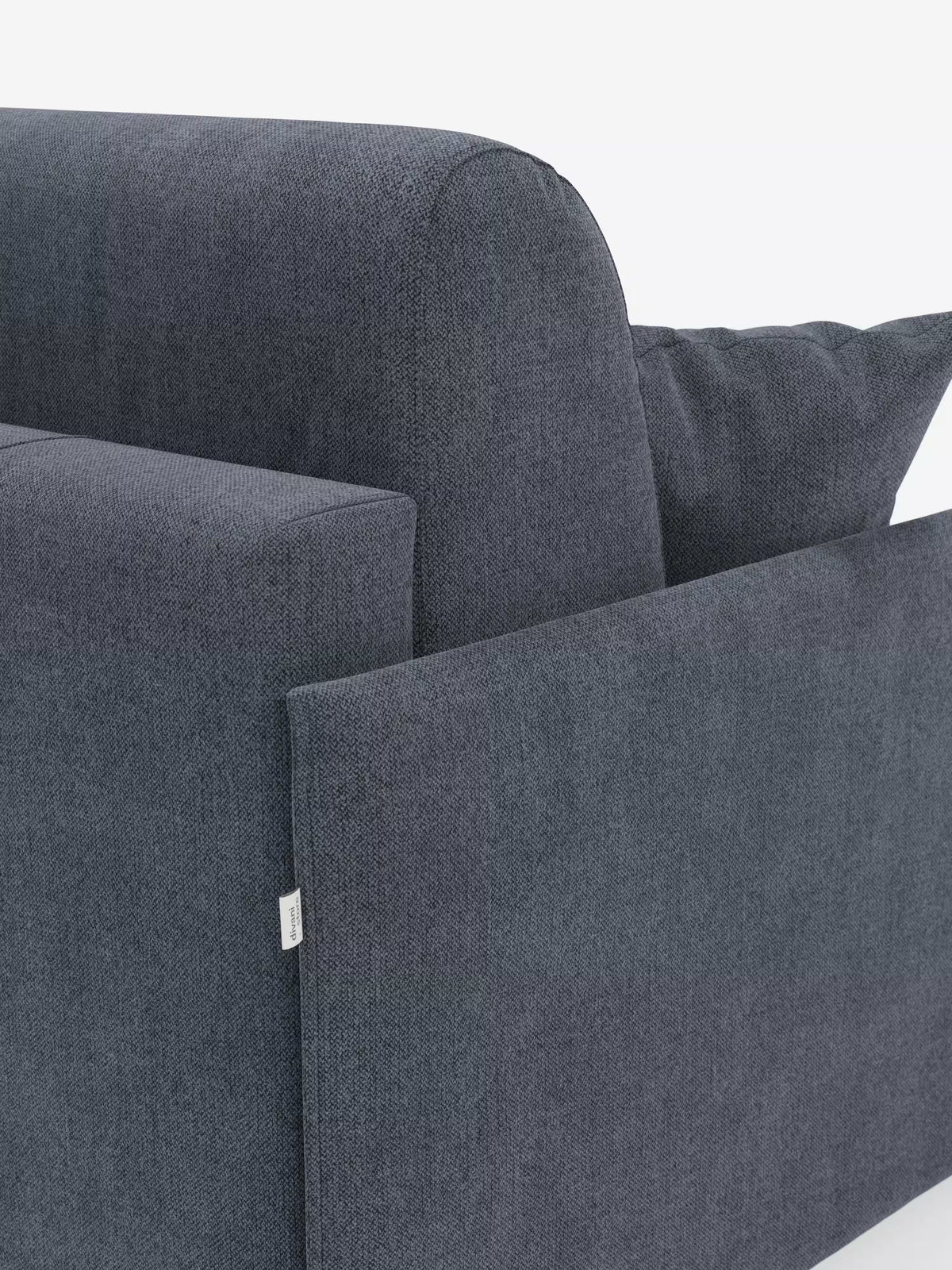 Primo piano del divano letto matrimoniale sfoderabile Evans di Divani.Store, caratterizzato da un design moderno e compatto in grigio scuro, con imbottitura spessa e un cuscino. Il tessuto T23, dalla trama rigata e resistente alle macchie, presenta una piccola etichetta bianca sul lato, mentre lo sfondo bianco a tinta unita mette in risalto le linee pulite e il minimalismo salvaspazio del divano. Uno scomparto nascosto offre uno spazio pratico dove riporre i cuscini.