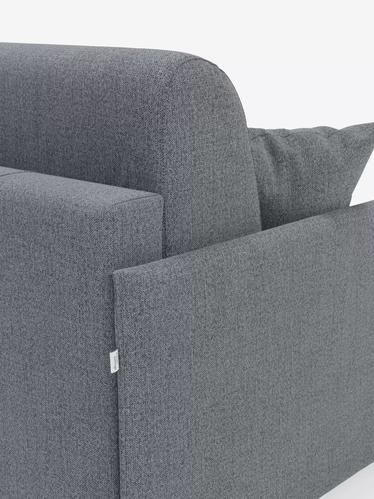 Primo piano del profilo laterale e del retro del divano letto matrimoniale sfoderabile Evans di Divani.Store, caratterizzato da un design moderno e compatto in tessuto grigio T23 smacchiabile con una trama leggermente ruvida. Il bracciolo rettangolare, l’etichetta con cucitura a vista e il cuscino coordinato risaltano su uno sfondo bianco a tinta unita. Questo modello è dotato di un pratico vano porta guanciali.