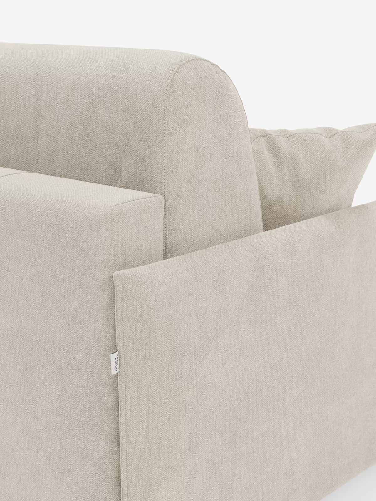 Un primo piano del divano letto matrimoniale sfoderabile Evans di Divani.Store mette in risalto il moderno design ad angolo con schienale dalle linee pulite, morbido cuscino di seduta, cuscino decorativo abbinato e una discreta etichetta in tessuto bianco sul pannello laterale. Realizzato in tessuto T23 smacchiabile e caratterizzato da un design compatto con vano porta guanciali nascosto, questo elegante divano salvaspazio è perfetto per ambienti versatili. Lo sfondo è bianco a tinta unita.