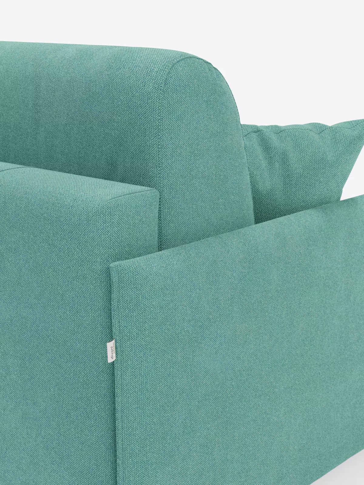 Primo piano del divano letto matrimoniale sfoderabile Evans di Divani.Store, caratterizzato da linee moderne e pulite e da un design compatto, realizzato in tessuto T23 antimacchia. L'immagine mette in risalto il bracciolo, lo schienale, il cuscino di seduta e un cuscino quadrato accuratamente sistemato in un angolo. Il rivestimento, dalla trama delicatamente ruvida, risalta sullo sfondo bianco a tinta unita.