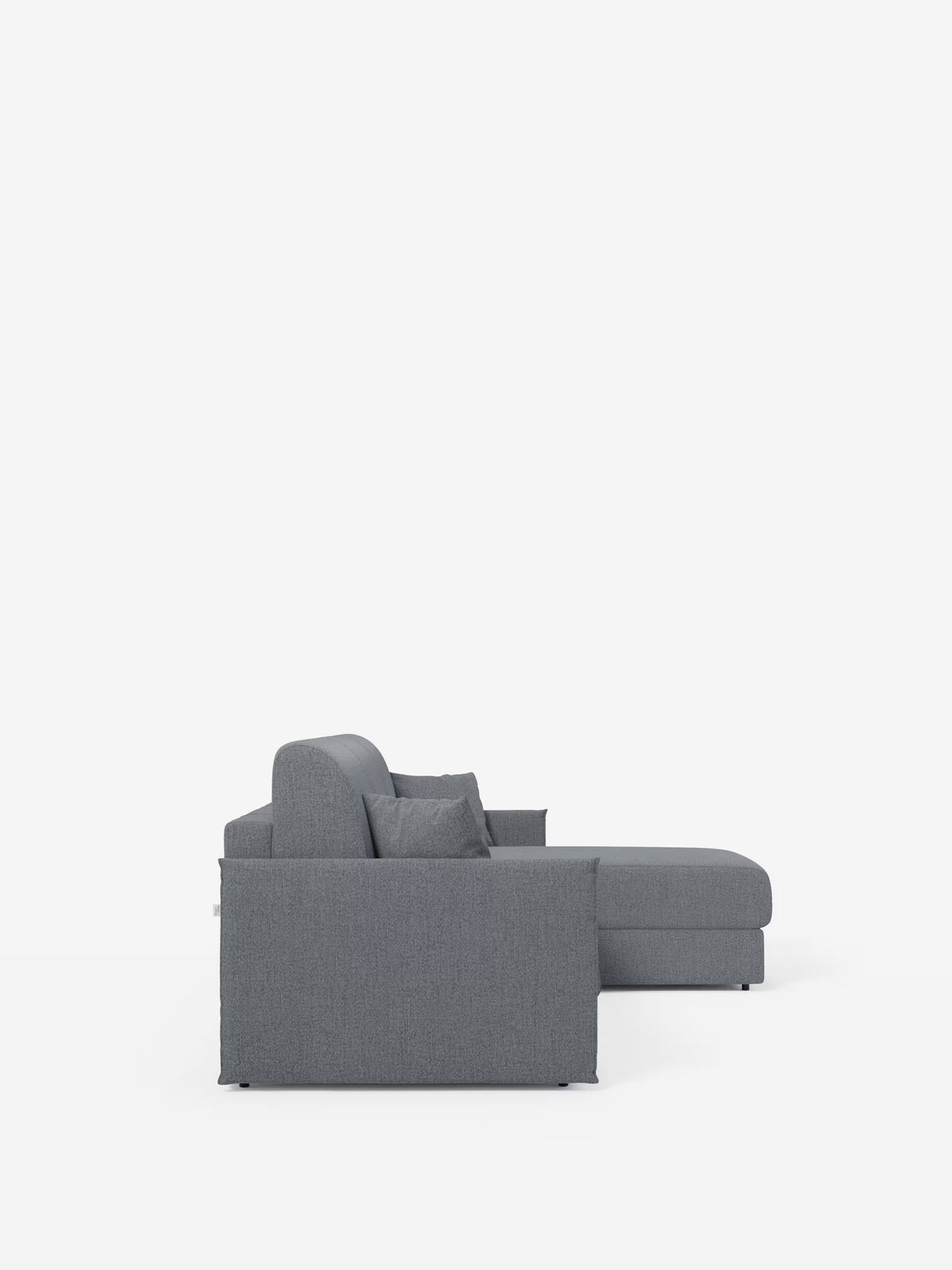 Vista laterale del “Evans Divano letto angolare con penisola contenitore” di Divani.Store, un moderno divano componibile grigio caratterizzato da una chaise longue sul lato destro e da un design compatto, rivestito in tessuto T23 facile da pulire. Il divano si caratterizza per le linee pulite, lo schienale basso e due cuscini quadrati appoggiati allo schienale. Lo sfondo bianco a tinta unita ne esalta lo stile minimalista.