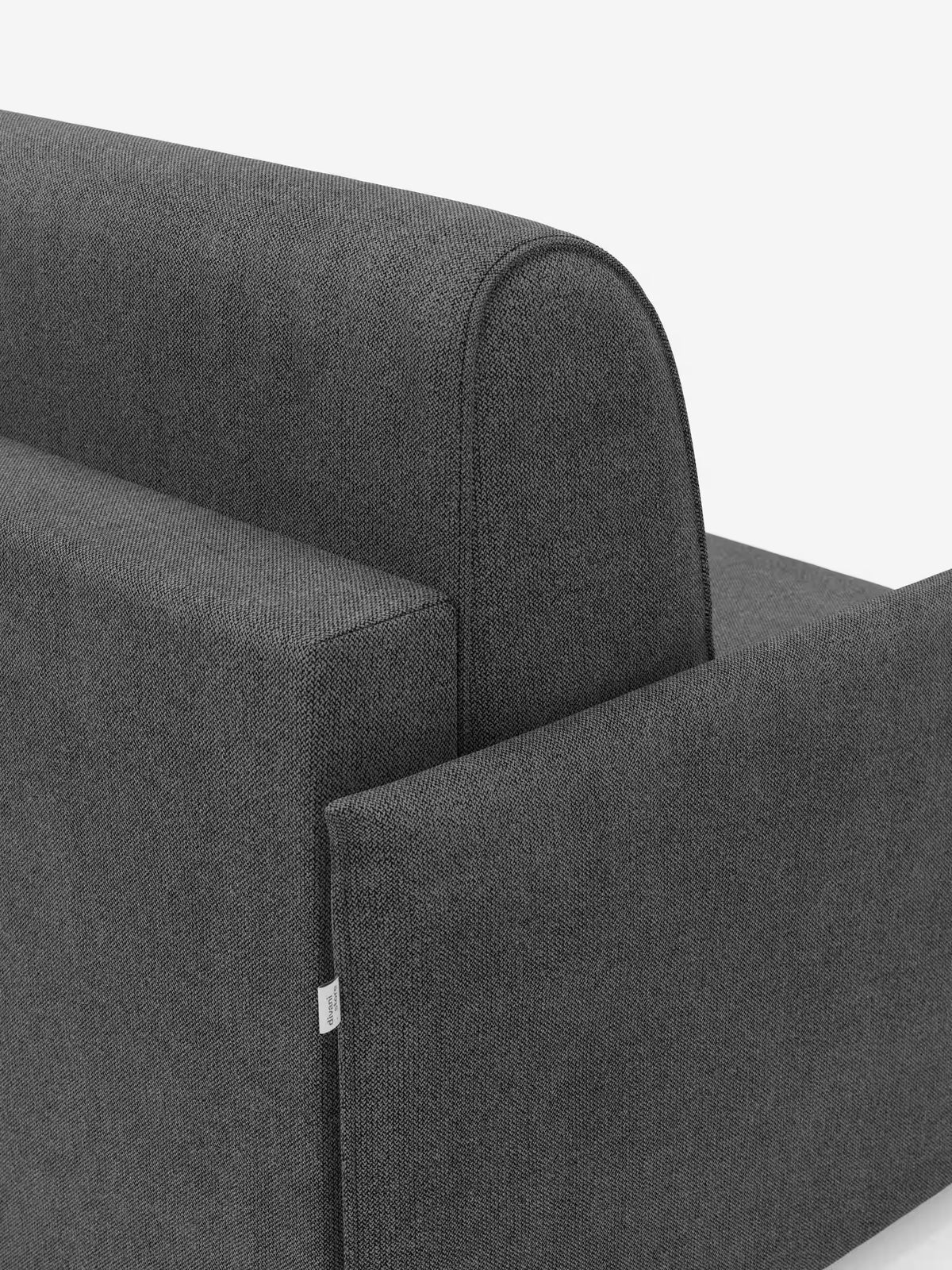 Primo piano della poltrona letto compatta Evans di Divani.Store con materasso, rivestita in tessuto T23 grigio scuro resistente alle macchie e sfoderabile, ritratta su sfondo bianco. L'immagine mette in risalto i braccioli, lo schienale, il motivo del rivestimento dalla trama leggermente ruvida e una piccola etichetta in tessuto sul lato. Questo versatile complemento d'arredo funge da poltrona letto salvaspazio, perfetta per gli spazi abitativi ridotti.