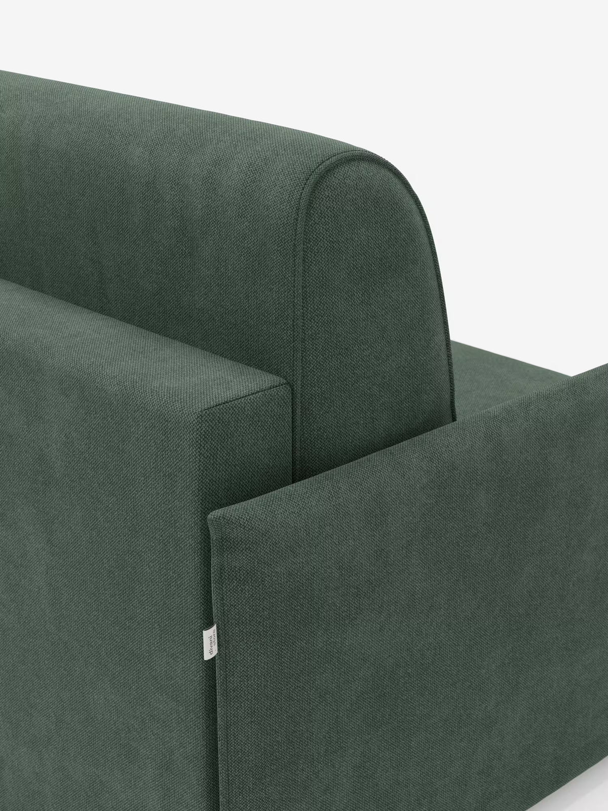 Un primo piano della poltrona letto compatta Evans con materasso di Divani.Store mostra il retro e il profilo laterale di questa moderna poltrona letto verde. Il rivestimento è realizzato in tessuto T23 testurizzato e resistente alle macchie, caratterizzato da linee pulite e angoli squadrati, che offre una soluzione salvaspazio versatile per gli spazi abitativi contemporanei. Una piccola etichetta in tessuto bianco è applicata alla cucitura sul lato sinistro. Lo sfondo è bianco a tinta unita.