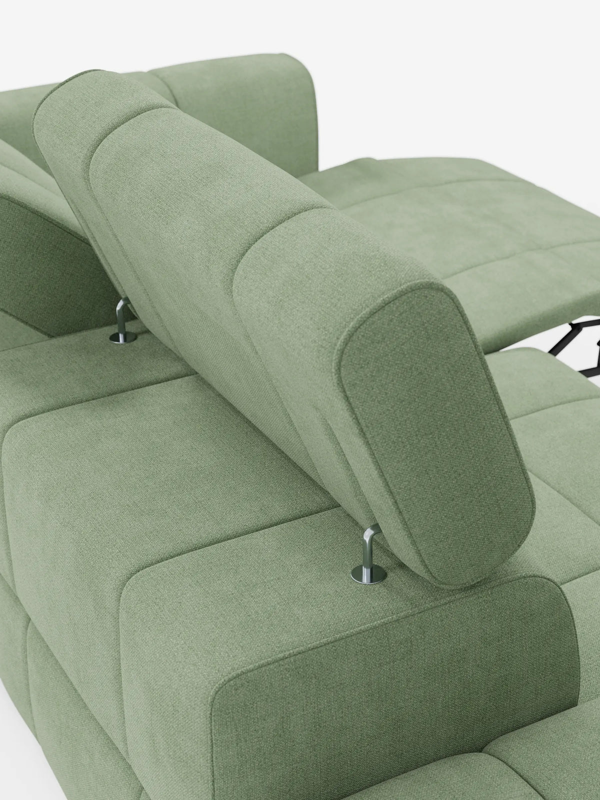 Un divano componibile Giotto di colore verde salvia con terminale aperto - opzione relax elettrico in tessuto smacchiabile T23, dotato di poggiatesta regolabili su supporti in metallo, tessuto testurizzato e una chaise longue con meccanismo di reclinazione a vista.