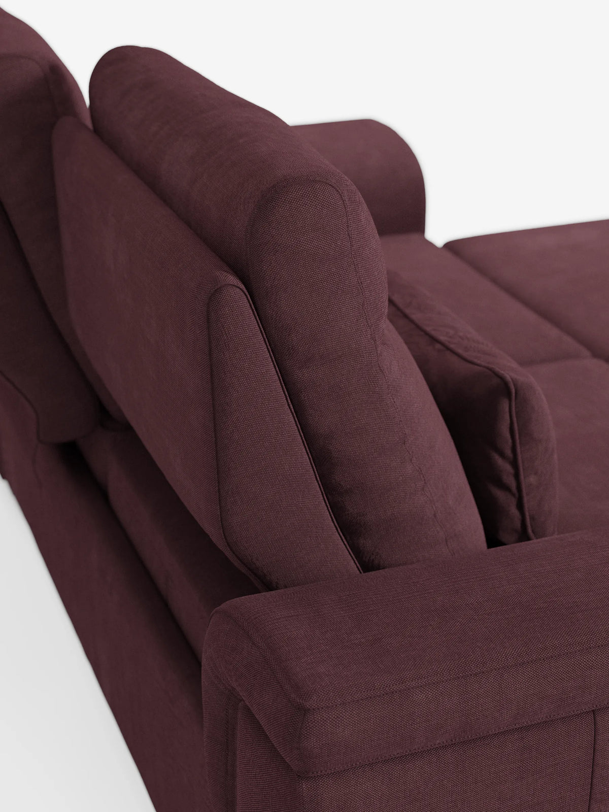 Un primo piano di un divano Ischia a 3 posti color bordeaux intenso, con pouf estraibile e schienali scorrevoli, realizzato in tessuto misto lino antimacchia, caratterizzato da una trama a rilievo e da linee pulite e moderne su uno sfondo bianco.