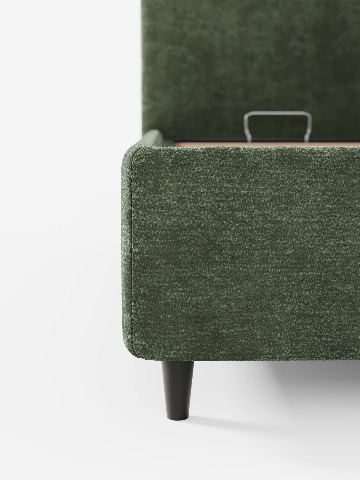 Un primo piano di un divano KAELOS “letto minimal” color verde bosco - con vano contenitore, gambe alte e testiera arrotondata in tessuto ciniglia.