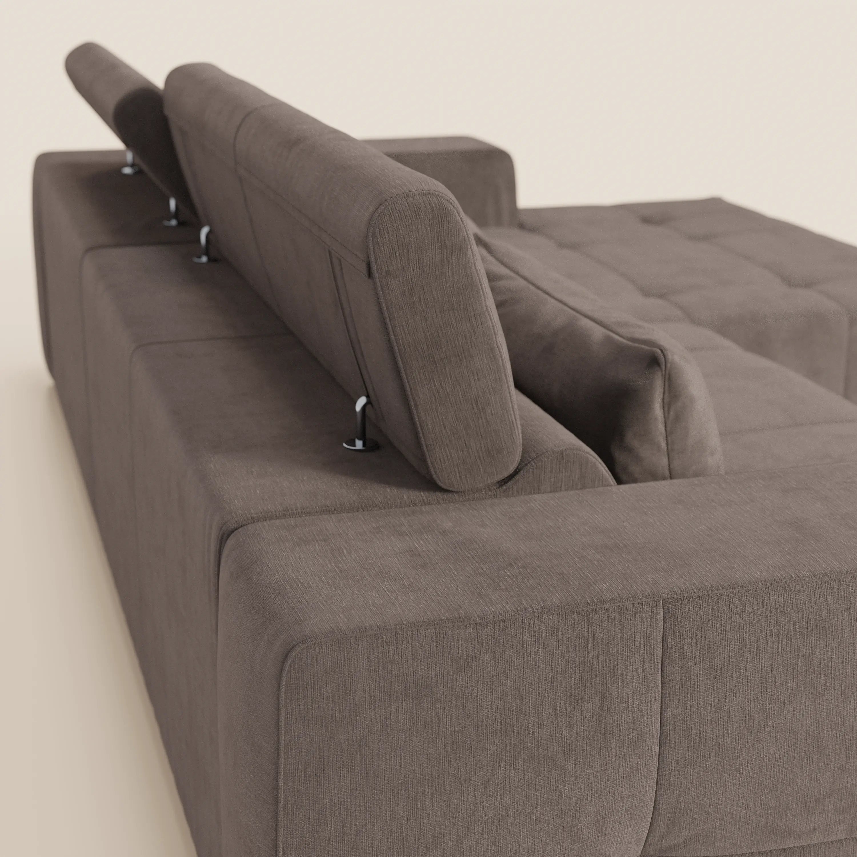 Il divano Monarch angolare con penisola e relax elettrico di Divani.Store è mostrato di spalle, con poggiatesta reclinabili, sedute allungabili, morbido tessuto smacchiabile T31 marrone e linee pulite su sfondo beige.