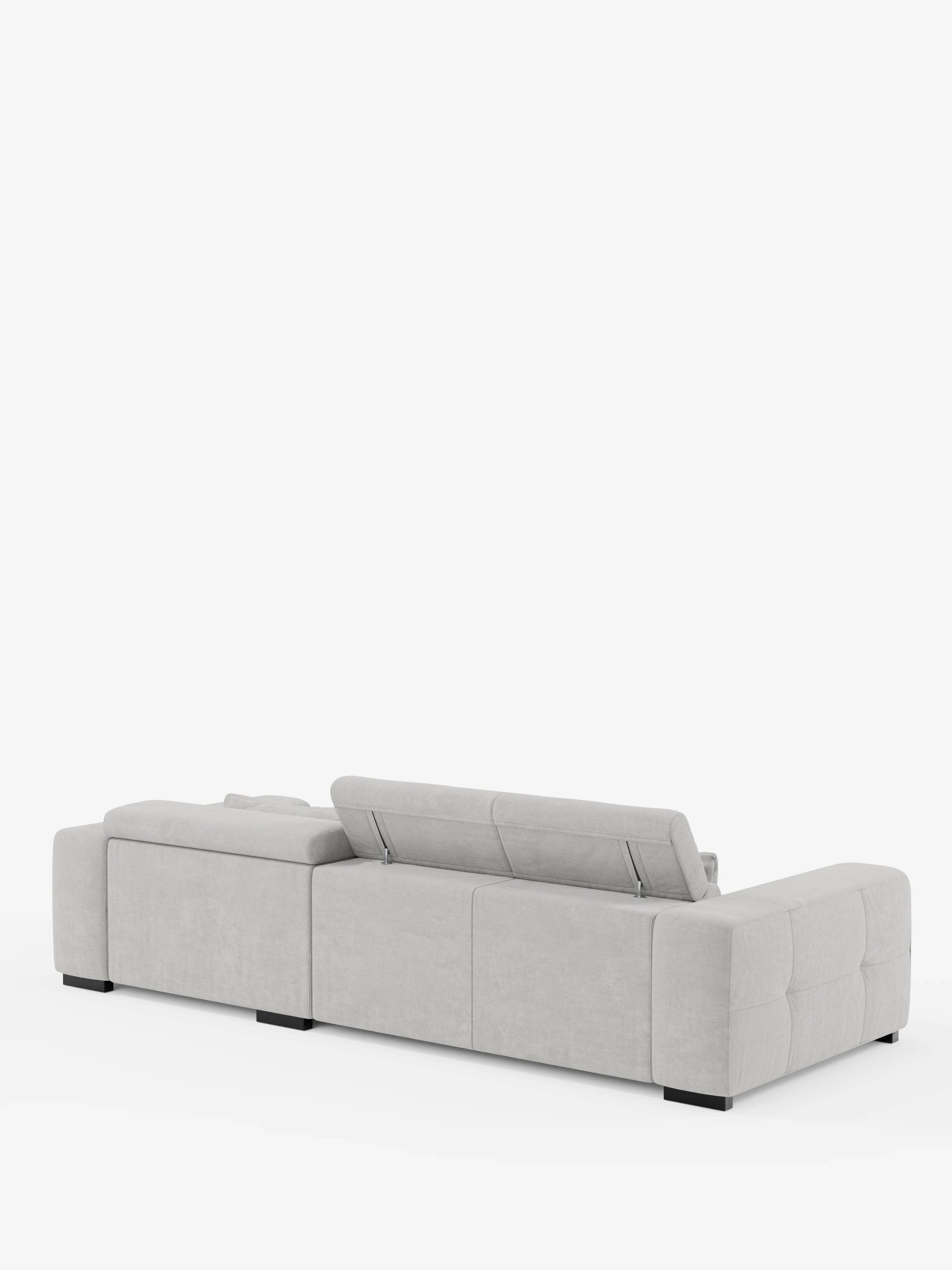 Il divano angolare Monarch con penisola e funzione relax elettrica per l’allungamento delle sedute di Divani.Store è ripreso da dietro, mettendo in risalto il suo design moderno in grigio chiaro, caratterizzato da un profilo basso e ampi braccioli. La seduta sinistra è dotata di un poggiatesta rialzabile e regolabile, mentre il divano poggia su bassi piedini neri su uno sfondo bianco. Realizzato in morbido tessuto T31 di facile manutenzione, questo divano componibile unisce comfort e stile.