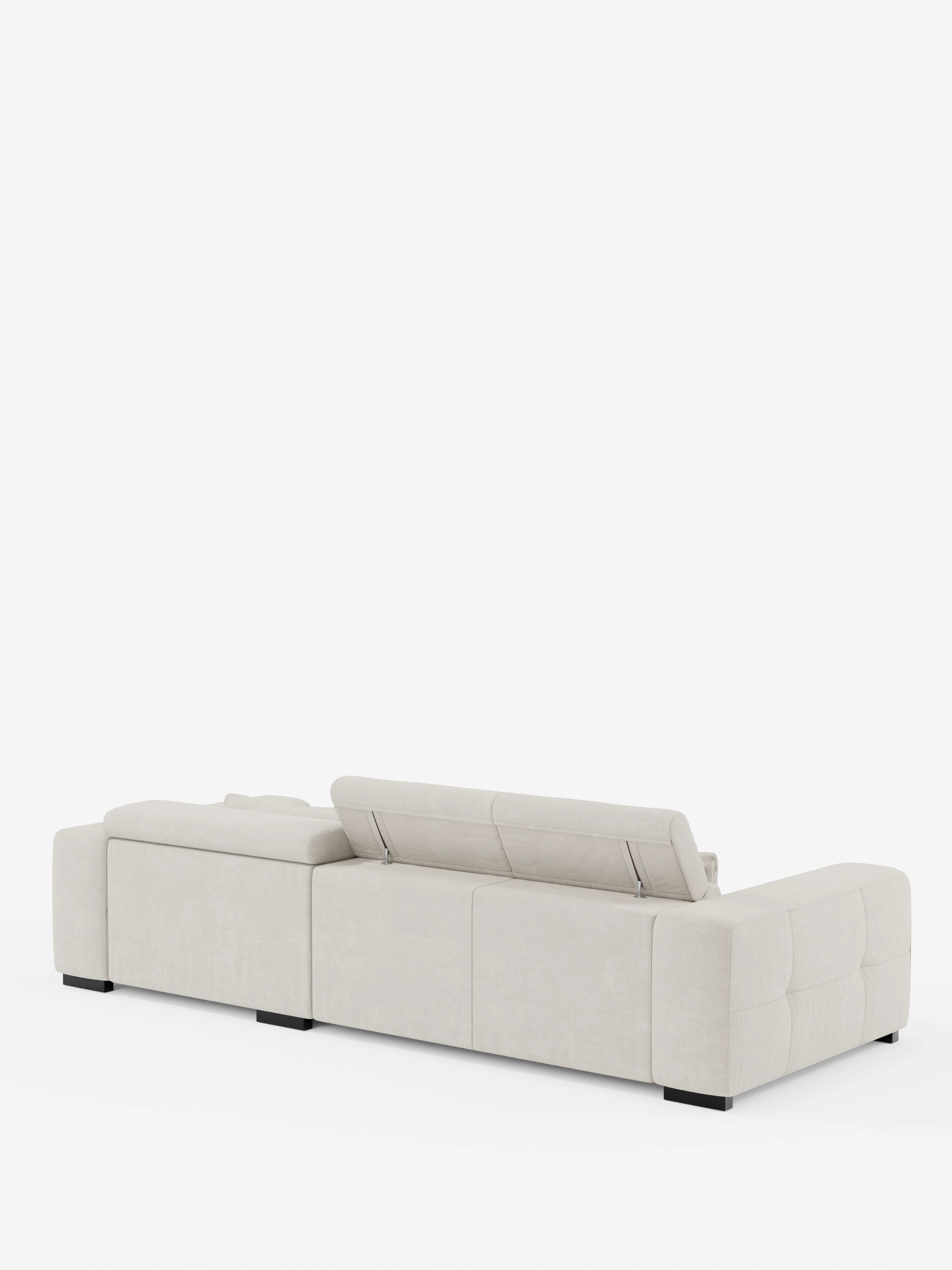 Il divano angolare Monarch con penisola e sistema Relax elettrico per l’allungamento delle sedute – poggiatesta reclinabili in morbido tessuto lavabile T31 di Divani.Store è raffigurato di retro in beige chiaro. Una delle sedute presenta un poggiatesta reclinabile in posizione verticale, mentre le altre rimangono piatte. Il divano componibile si contraddistingue per i braccioli bassi e larghi, i dettagli trapuntati squadrati e le gambe nere a profilo ribassato su sfondo bianco.