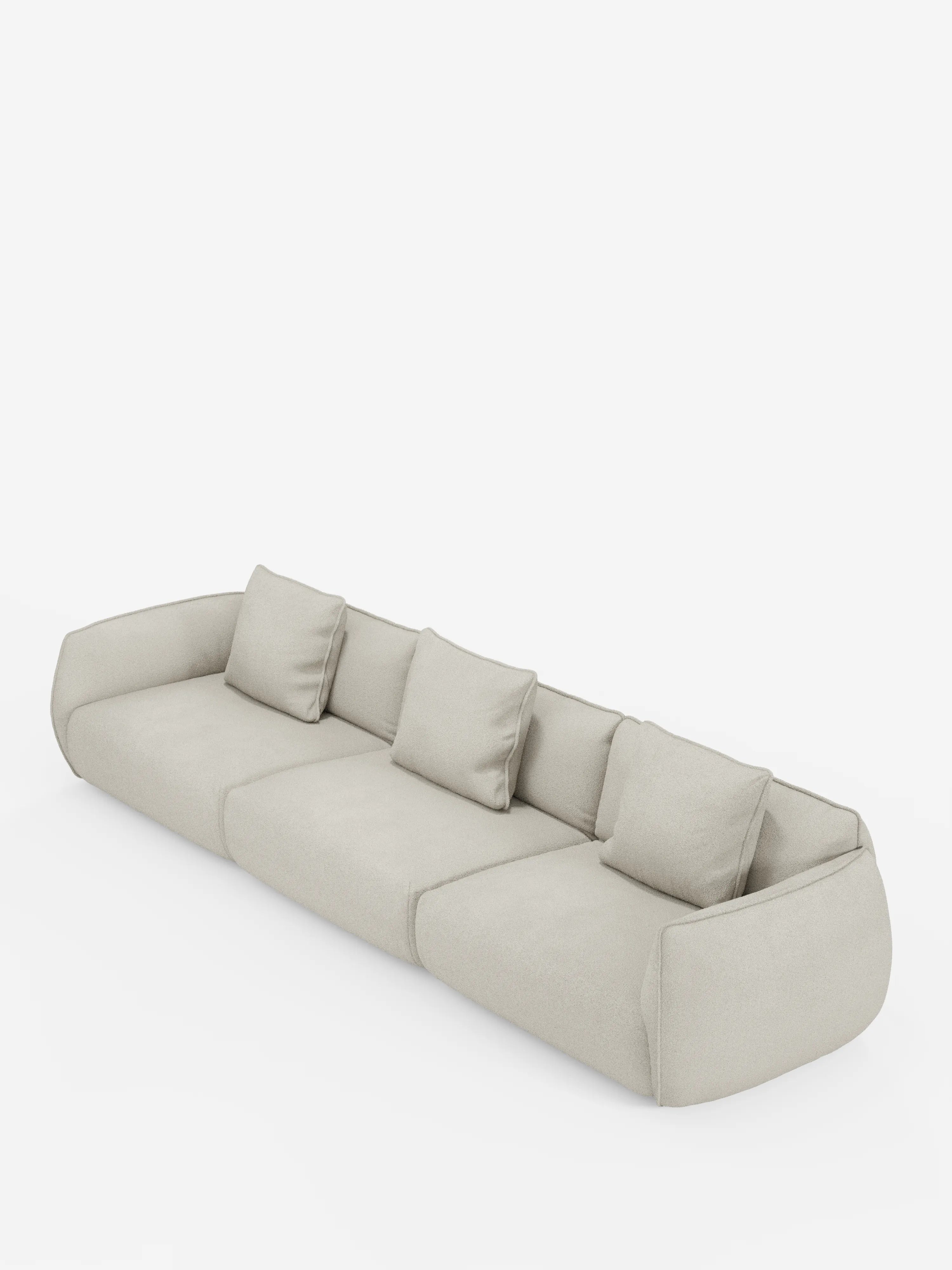 Un divano modulare Nimbus moderno e dal profilo basso a 3 posti di Divani.Store, rivestito in tessuto effetto cotone beige chiaro, morbido e resistente alle macchie (T33). Il design minimalista presenta bordi delicatamente arrotondati, tre sezioni di seduta e tre cuscini squadrati abbinati per lo schienale. Il divano è fotografato su uno sfondo bianco a tinta unita.