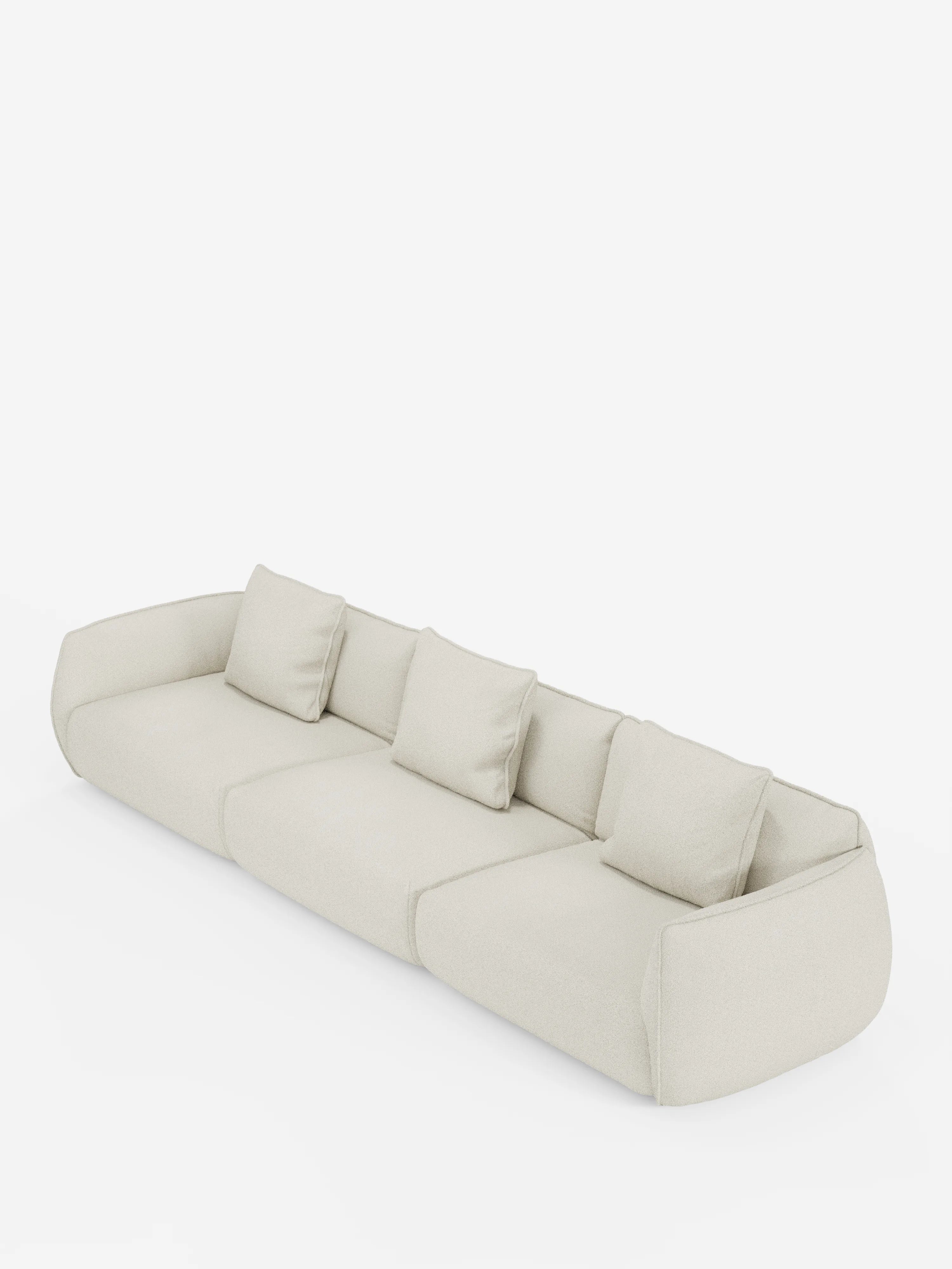 Un divano modulare Nimbus dal design minimalista e moderno, color crema, a 3 posti, di Divani.Store, realizzato in morbido tessuto T33 effetto cotone resistente alle macchie, con tre cuscini di seduta e cuscini quadrati abbinati, caratterizzato da bordi arrotondati e braccioli bassi e spessi, su sfondo bianco.