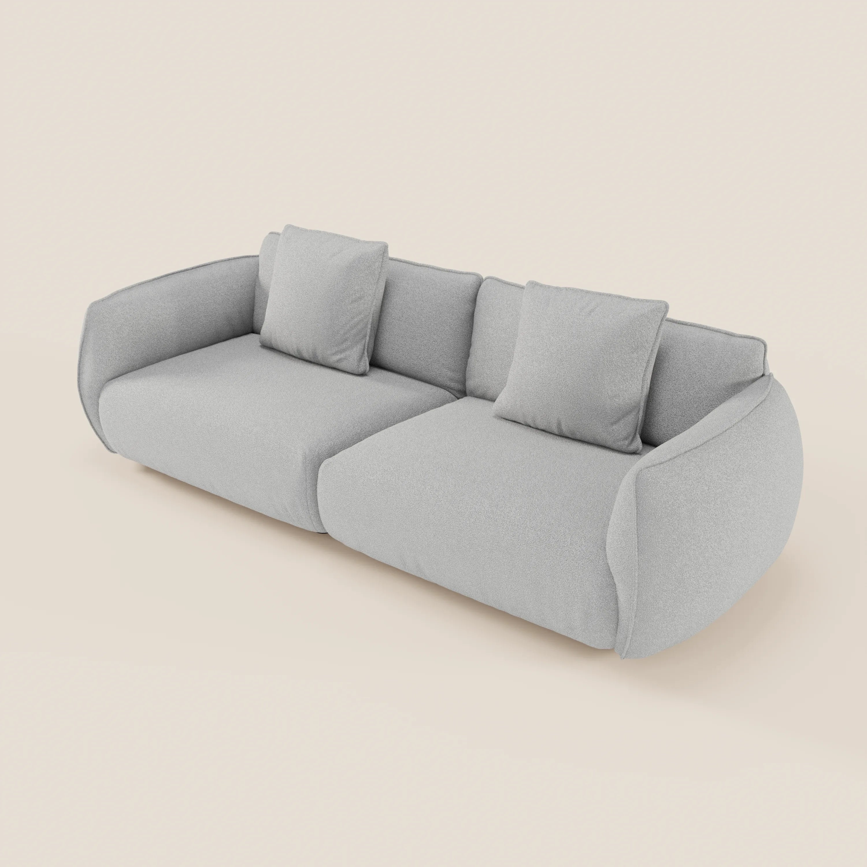 Il divano Nimbus 3 posti modulare di Divani.Store è un moderno divano grigio chiaro con bordi arrotondati, ampi braccioli e tre cuscini schienale, su sfondo bianco sporco. Due cuscini quadrati sono posizionati sulla seduta. Sfoderabile in tessuto smacchiabile.
