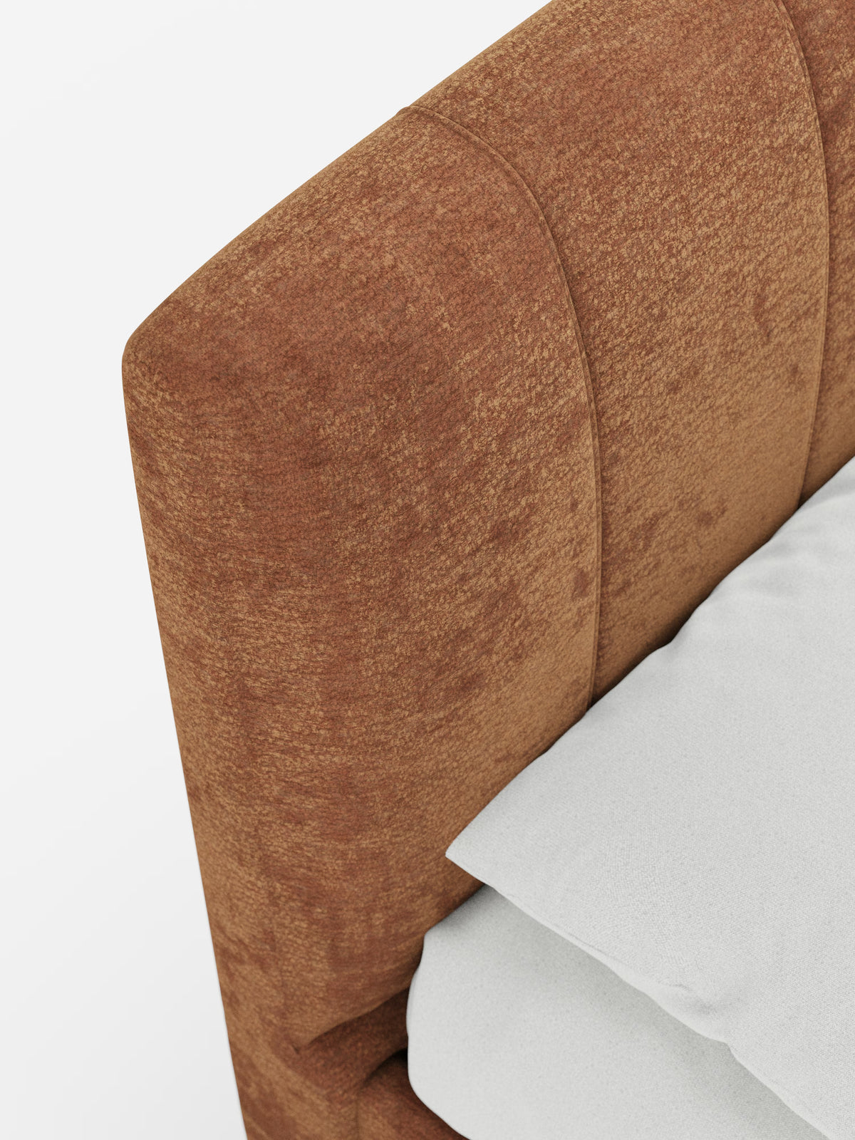 Primo piano di un letto: il modello ONYX di Letti.store, letto imbottito con vano contenitore e testiera verticale in tessuto certificato Oeko-Tex®. Una testiera imbottita dal colore ruggine, con dettagli verticali, crea un elegante contrasto con la biancheria da letto di un bianco candido: un cuscino e una parte di lenzuolo o coperta poggiano invitanti contro la testiera. Il tessuto certificato, morbido e vellutato, esalta la sensazione di comfort e raffinatezza, in netto contrasto con lo sfondo bianco a