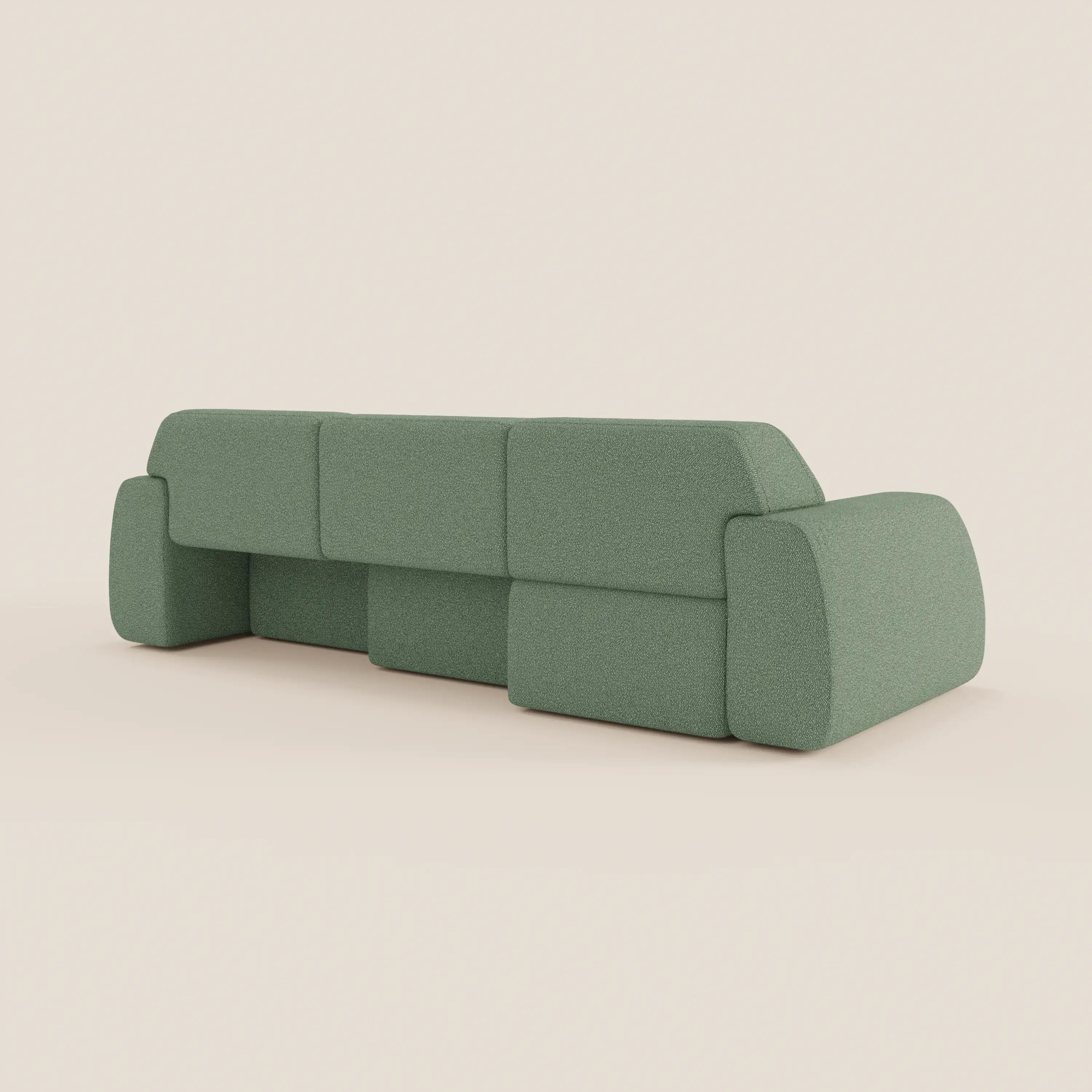 Il divano angolare Orbit di Divani.Store, in tessuto smacchiabile effetto cotone T33 verde salvia, presenta un design minimalista a blocchi con tre cuscini di schienale, ampi braccioli arrotondati e sedute allungabili. Mostrato dal retro su sfondo beige.