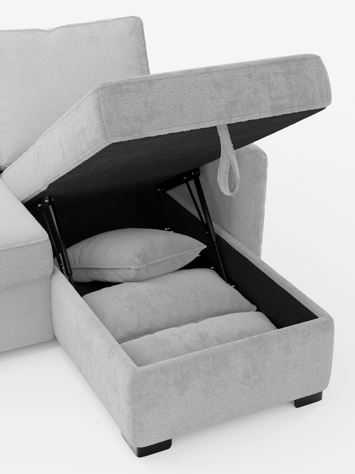 Un divano letto Ottaviano con letto estraibile, penisola reversibile e contenitore in tessuto materico smacchiabile color grigio chiaro, con la chaise longue sollevata per rivelare un vano portaoggetti che ospita due cuscini rettangolari riposti con cura.