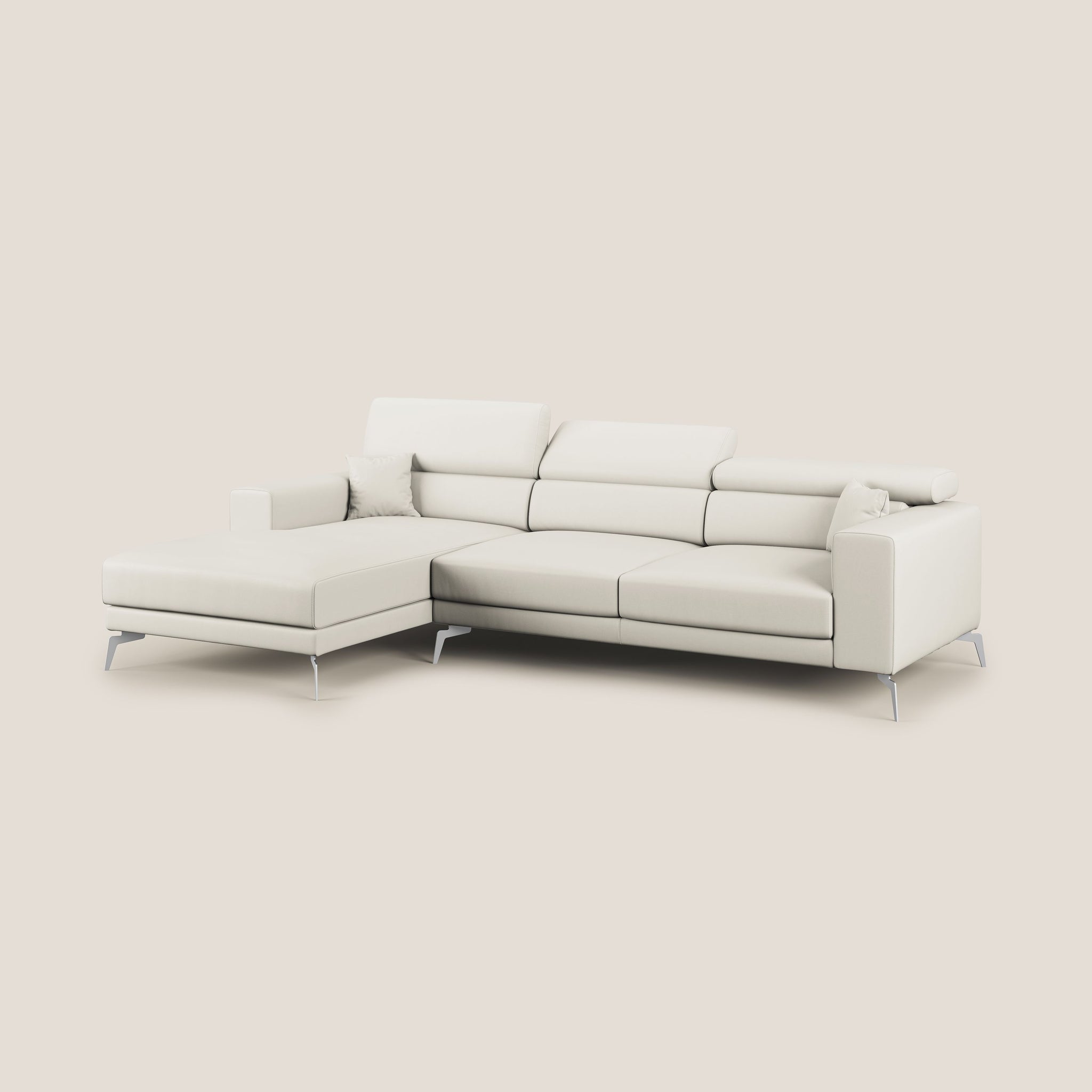 Un elegante e moderno Divano angolare sinistro Blade a forma di L di Divani.Store in Ecopelle T04 bianco con chaise longue a sinistra. Il divano è dotato di poggiatesta reclinabili ed è sollevato su sottili gambe metalliche su uno sfondo color crema. Due cuscini coordinati sono posizionati sulla chaise longue.