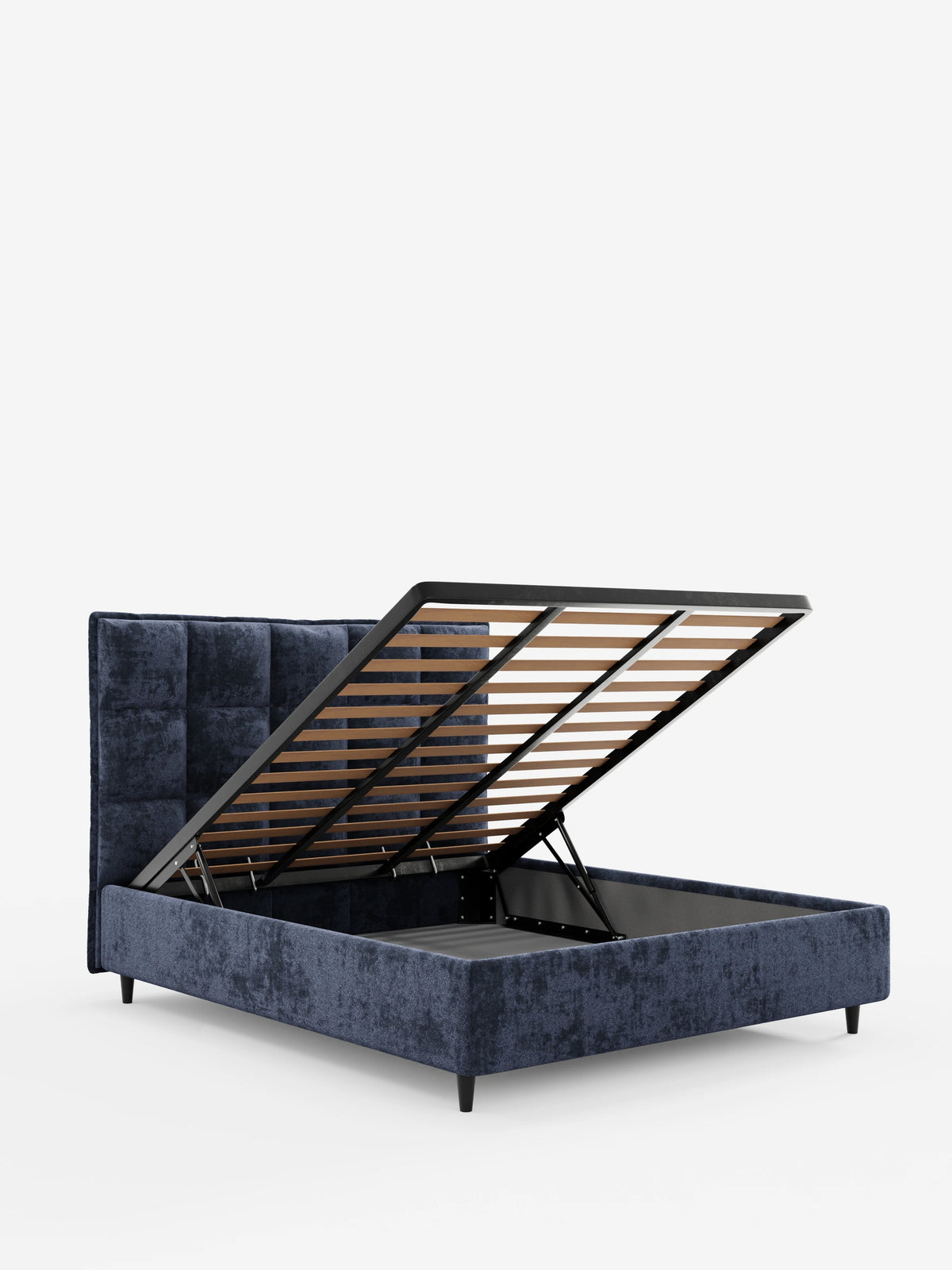 Un letto imbottito AURO blu navy con vano contenitore e testiera alta capitonné in ciniglia Oeko-Tex®, caratterizzato da una testiera alta con trapuntatura quadrata, che mostra la base del materasso inclinata verso l’alto per rivelare un vano contenitore con supporti a doghe in legno.