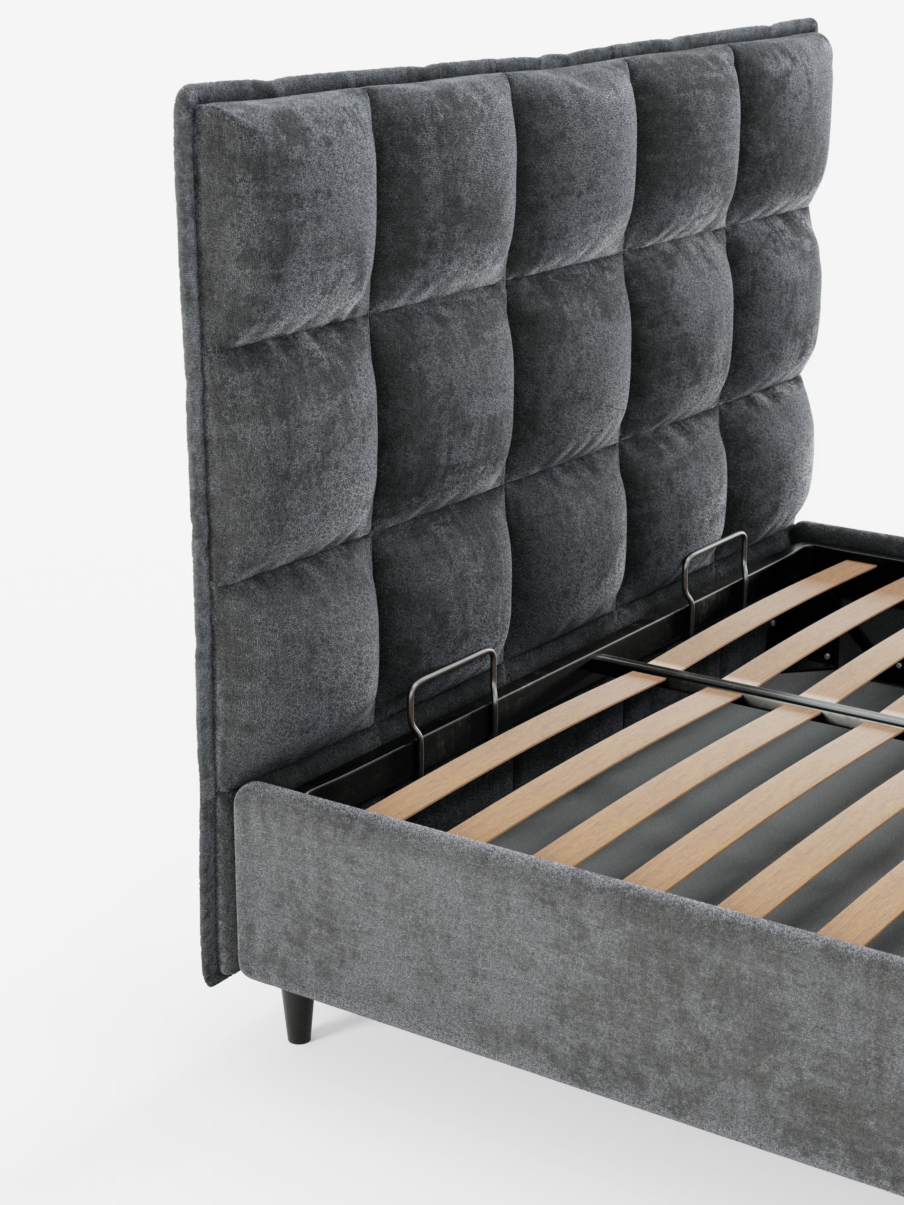 Un primo piano del letto imbottito AURO con contenitore e testiera capitonné alta in ciniglia Oeko-Tex® di Letti.store, che mette in risalto il suo design moderno con una testiera alta capitonné in ciniglia grigio scuro e doghe in legno a vista per il sostegno del materasso. La struttura del letto poggia su corte gambe nere su uno sfondo bianco a tinta unita.