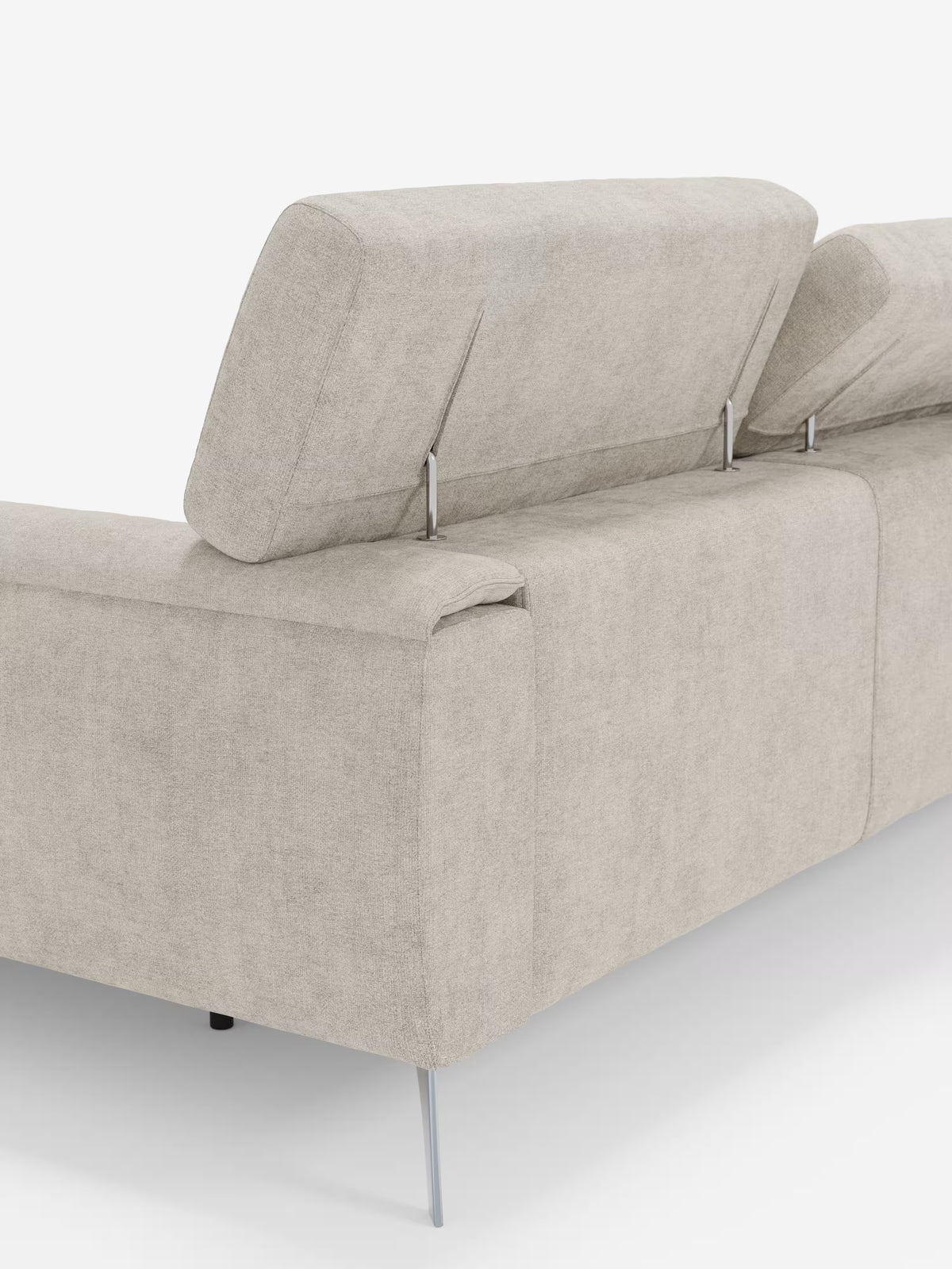 Il divano angolare Caravaggio con penisola e sedute scorrevoli in tessuto smacchiabile T31 di Divani.Store è ripreso dall’angolo posteriore, caratterizzato da un rivestimento moderno in tessuto beige dall’aspetto liscio e minimalista. Il divano è sostenuto da sottili gambe in metallo, mentre i poggiatesta parzialmente rialzati su supporti metallici e le sedute scorrevoli garantiscono un comfort superiore. Lo sfondo è bianco a tinta unita.