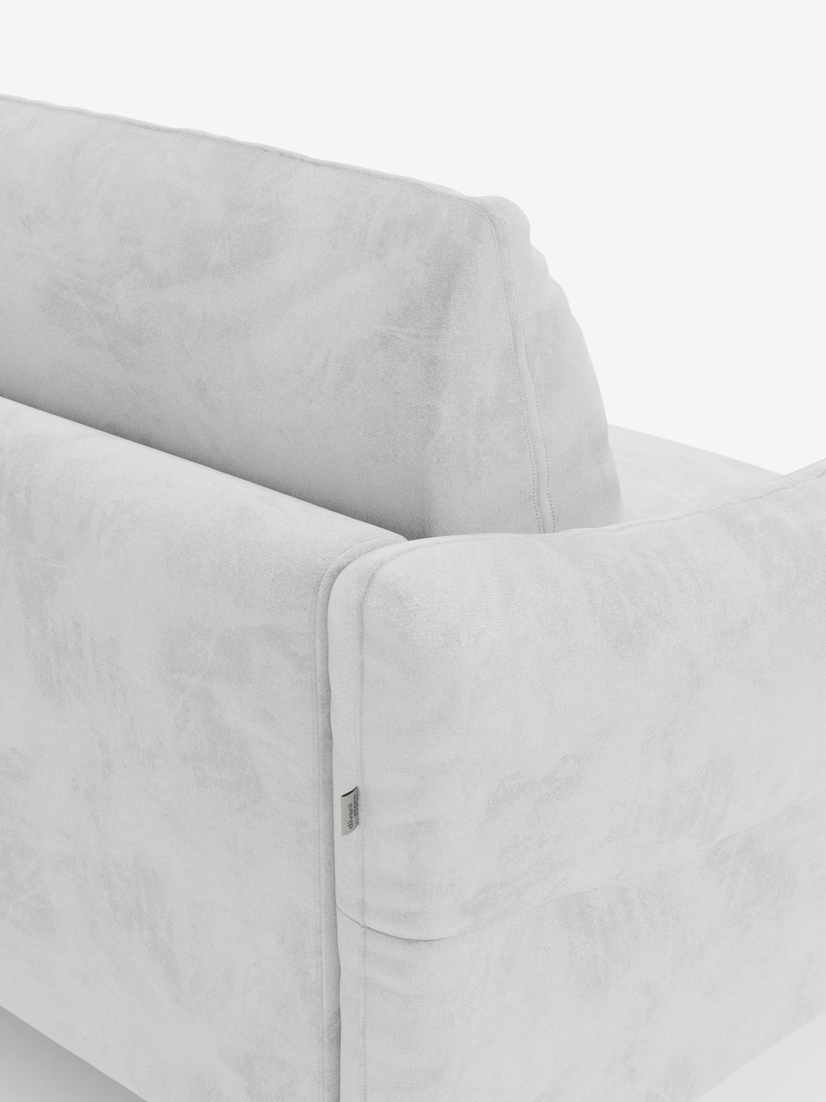 Un primo piano del retro e del profilo del divano letto Dalia a 2, 3 e 4 posti di Divani.Store mette in risalto il suo rivestimento in morbido velluto grigio chiaro T30 resistente alle macchie. L’immagine mette in risalto le cuciture precise, l’imbottitura generosa progettata per un materasso H18 e una discreta etichetta metallica sul lato, il tutto su uno sfondo bianco a tinta unita.