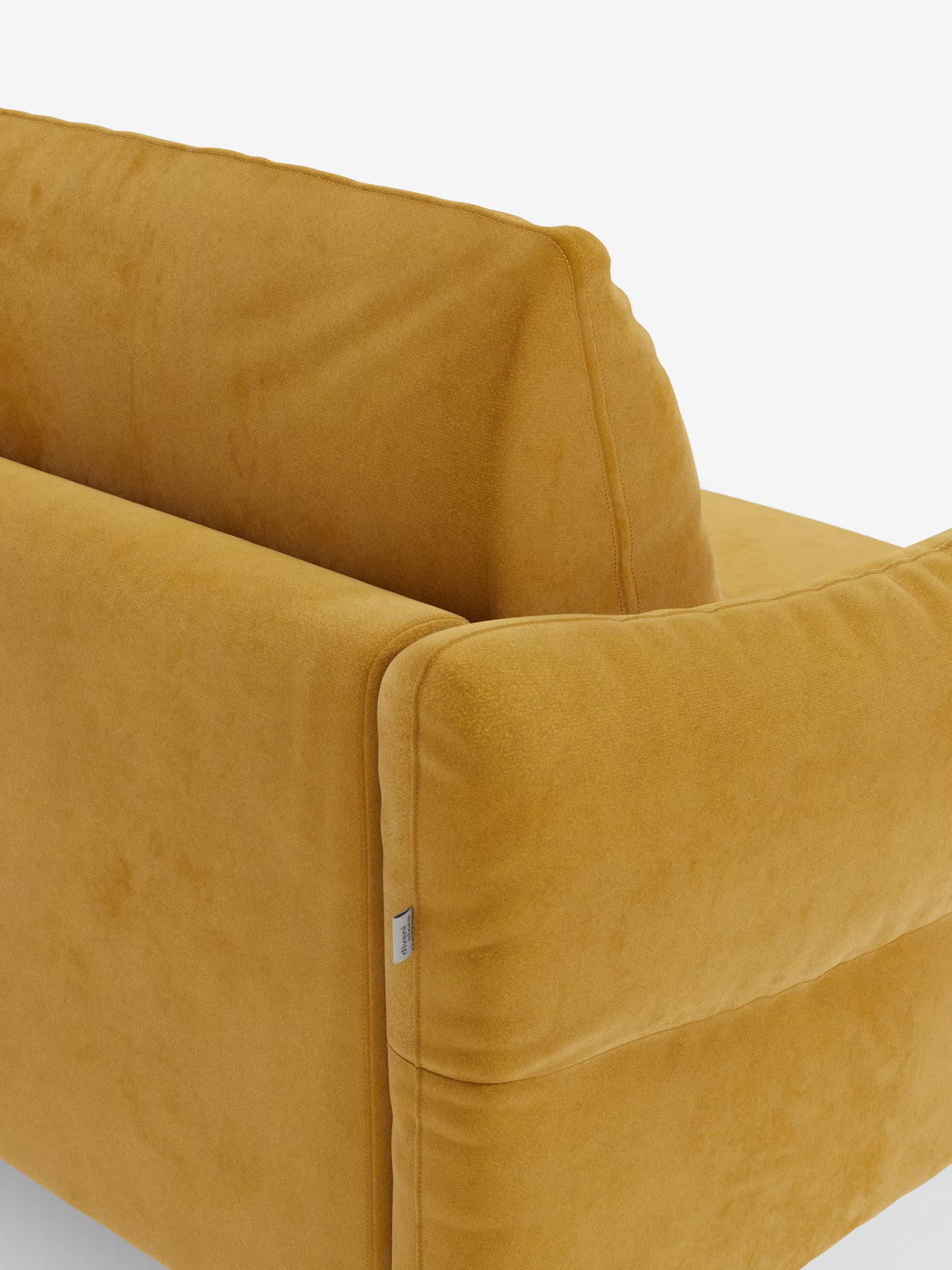 Primo piano di un divano letto Dalia di Divani.Store color giallo senape, rivestito in vellutino T30 moderno e resistente alle macchie. L'immagine mostra lo schienale e il bracciolo, mettendo in risalto la consistenza morbida e soffice, i dettagli delle cuciture pulite e una piccola etichetta in tessuto sulla cucitura. Lo sfondo è bianco a tinta unita.
