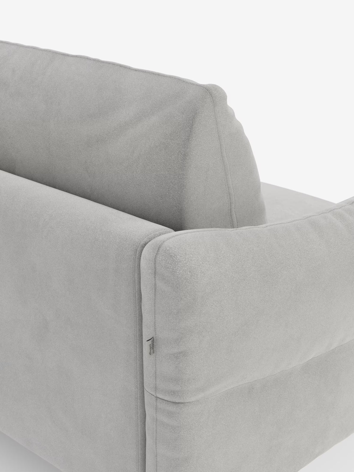 Primo piano del divano letto Dalia di Divani.Store in grigio chiaro, che mette in risalto i morbidi braccioli e lo schienale. Rivestito in moderno tessuto T30 vellutino, resistente alle macchie, dalla morbida consistenza simile alla pelle scamosciata. I dettagli delle cuciture a vista risaltano sullo sfondo bianco, rendendo questo divano letto a 2, 3 o 4 posti con materasso H18 il protagonista dell’immagine.