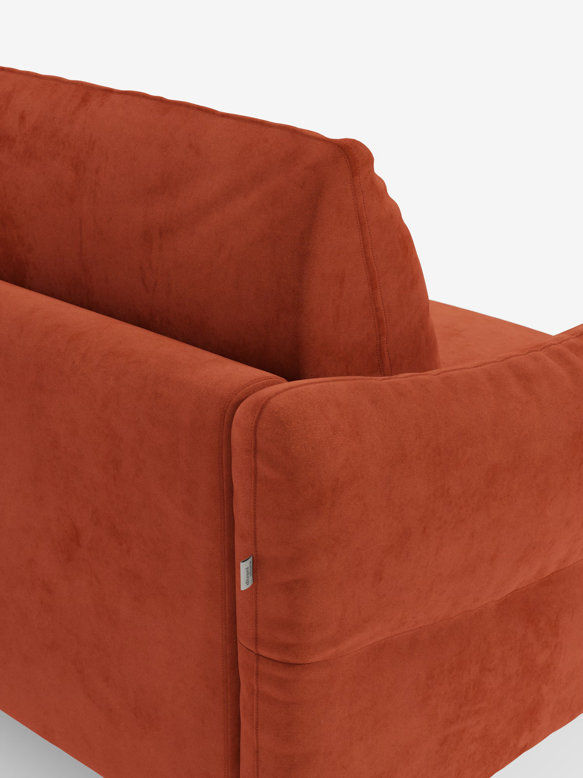 Una vista ravvicinata del divano letto Dalia a 2, 3 e 4 posti con materasso H18 di Divani.Store, rivestito in moderno tessuto vellutino T30 color arancione bruciato e resistente alle macchie. L'immagine mette in risalto lo schienale e il profilo laterale del divano letto, con una sottile cucitura e una piccola etichetta in tessuto sul lato. La trama soffice e morbida ne sottolinea il comfort, che lo rende un divano letto eccezionalmente comodo, in risalto su uno sfondo bianco a tinta unita.