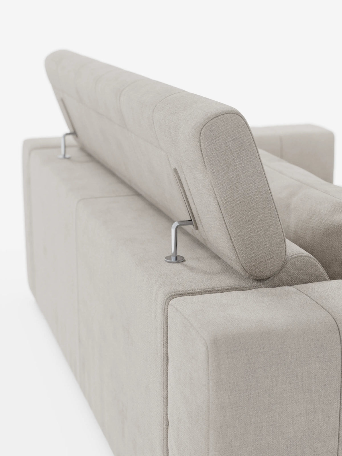 Nella foto, vista dal lato posteriore sinistro, è raffigurato un divano a tre posti Doric color beige di Divani.Store, con rivestimento smacchiabile T23 e poggiatesta reclinabile. Il poggiatesta rialzato con supporti in metallo mette in risalto le linee pulite e moderne del divano e la morbida trama del tessuto su uno sfondo bianco a tinta unita.