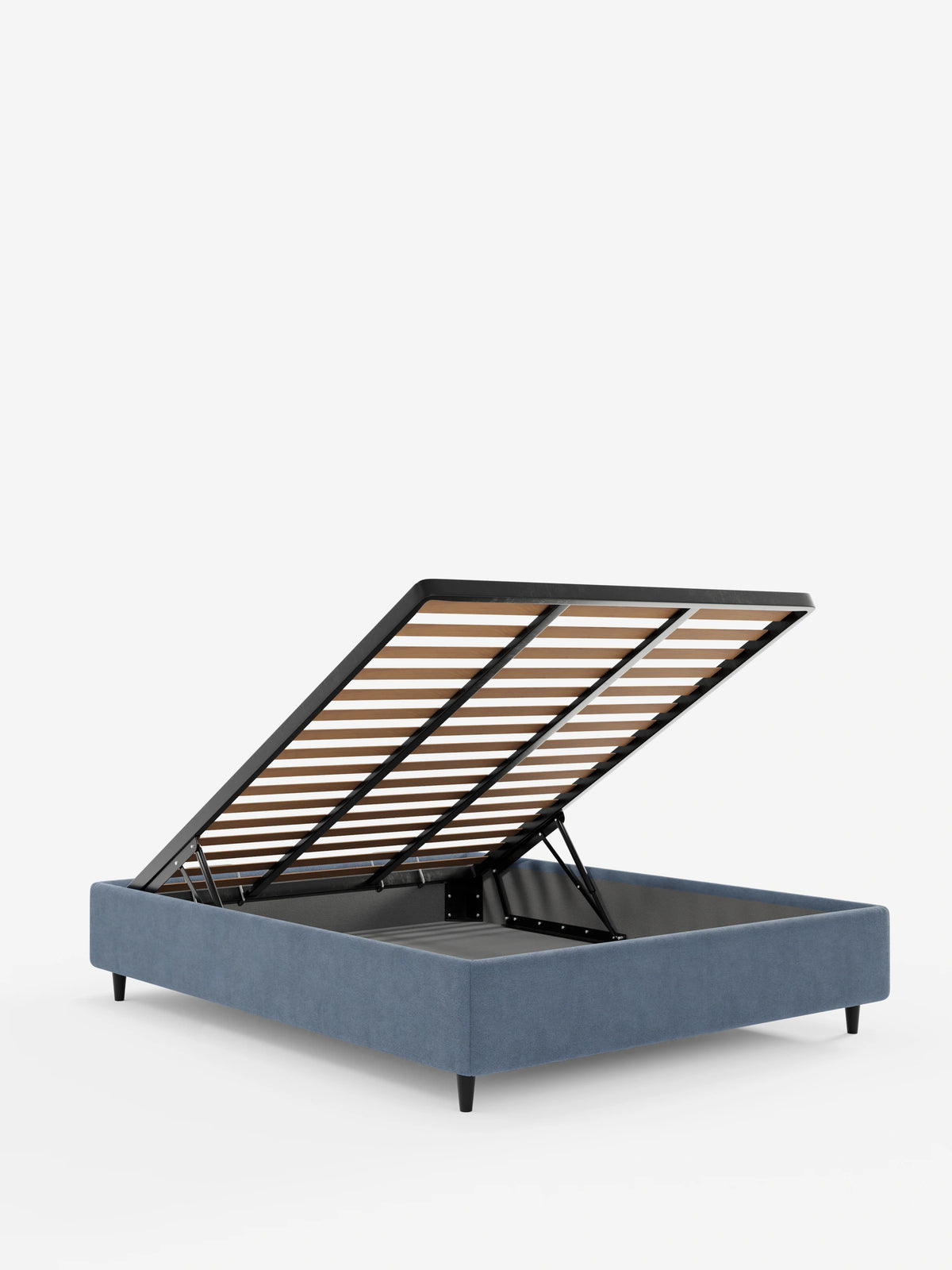 Un letto sommier ERON imbottito di colore blu, dotato di vano contenitore in tessuto impermeabile certificato Oeko-Tex, con la rete a doghe sollevata per rivelare lo spazio di stivaggio, sostenuto da quattro gambe sottili di colore scuro su uno sfondo bianco.