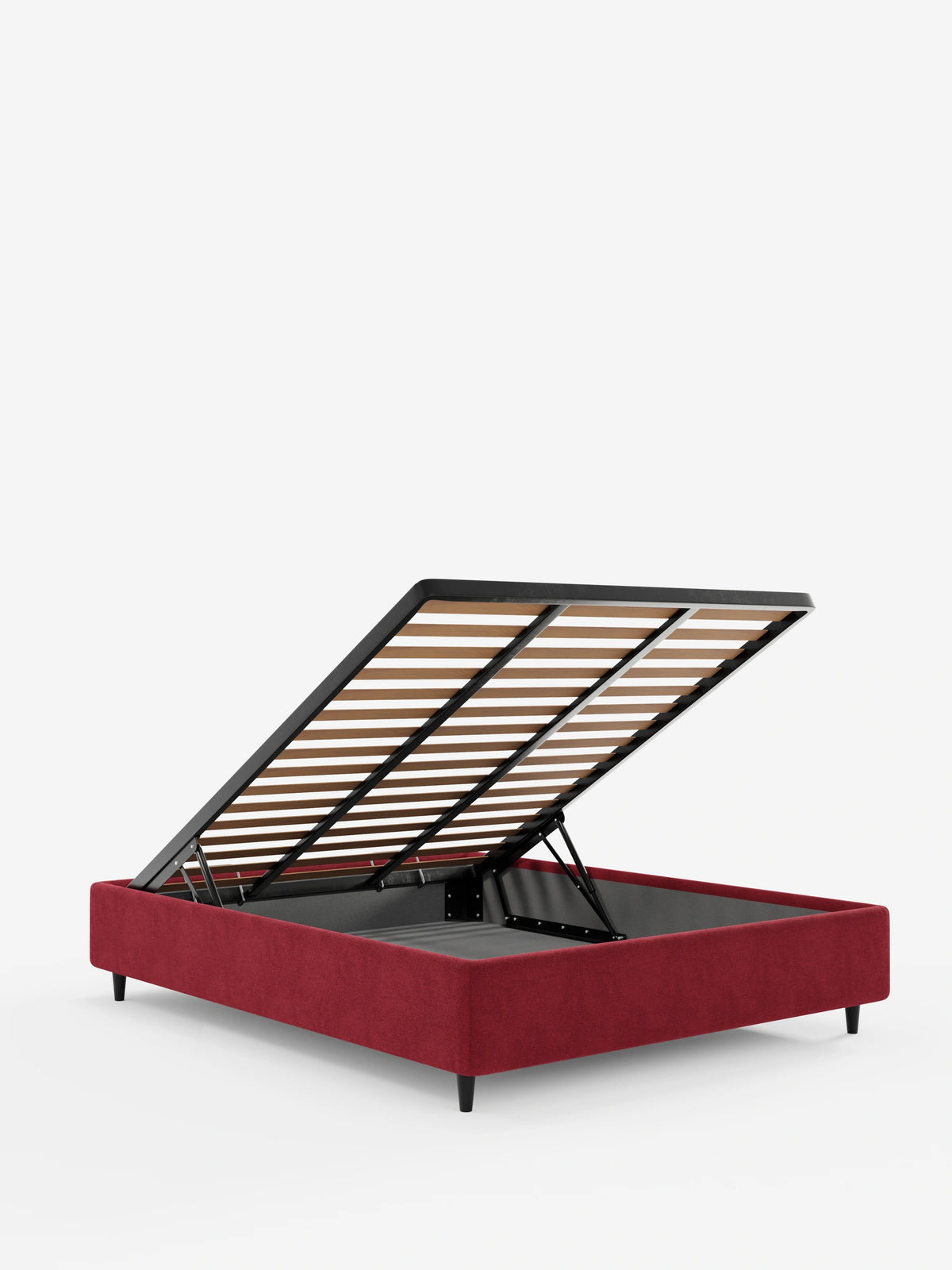 Un letto sommier imbottito ERON con vano contenitore in tessuto impermeabile certificato Oeko-Tex color rosso scuro, ripreso di profilo con la rete a doghe sollevata per mostrare il vano contenitore, su piccole gambe scure, su uno sfondo bianco a tinta unita.