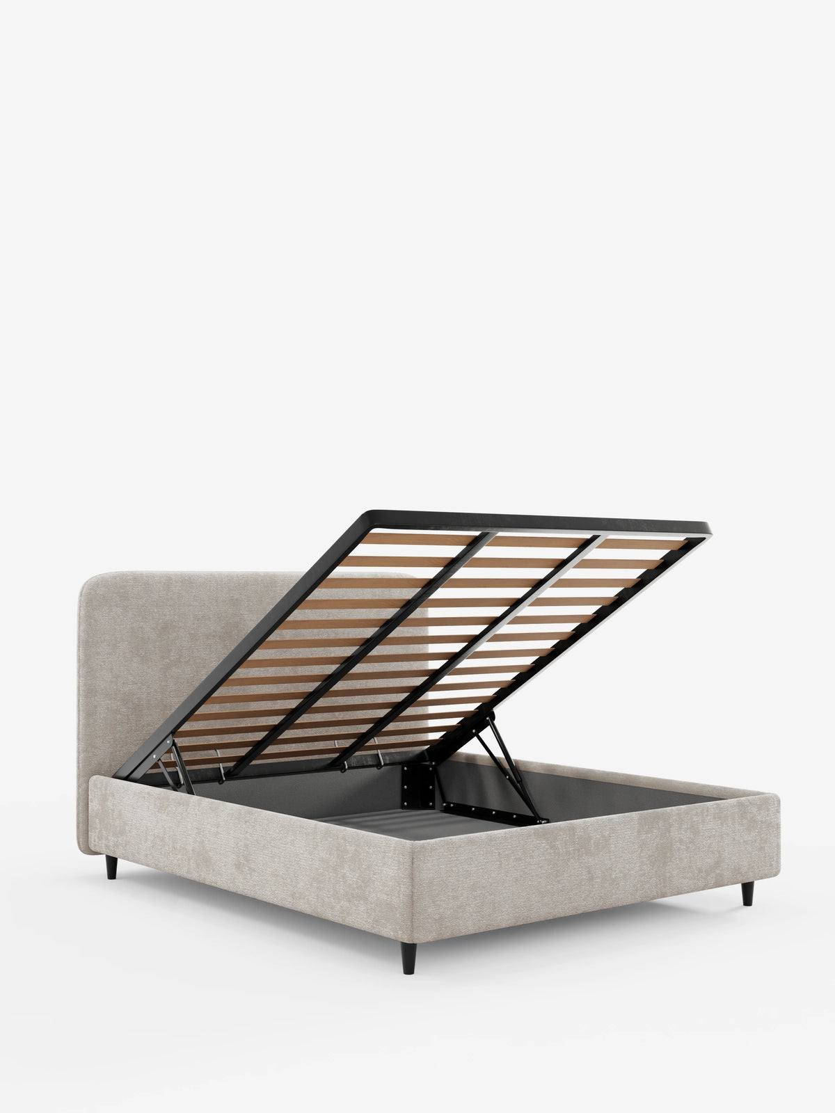 Un letto KAELOS beige in stile minimal imbottito - con vano contenitore, gambe alte e testiera arrotondata in tessuto ciniglia, con la testiera arrotondata e le gambe alte nere; nella foto, la rete a doghe è sollevata per mostrare il vano contenitore su uno sfondo bianco.