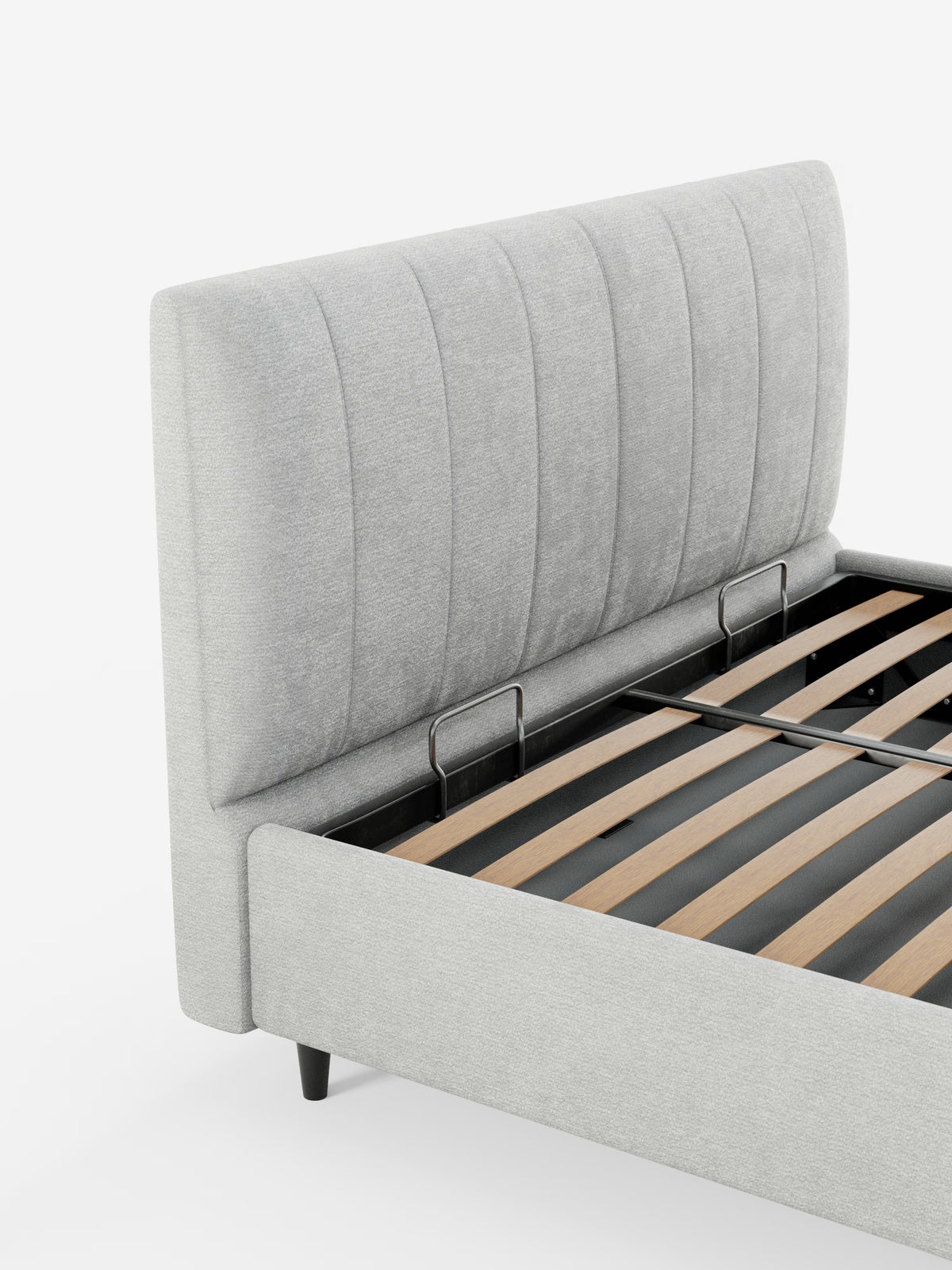 Ecco la frase riscritta utilizzando i dati del prodotto forniti: Un primo piano del letto imbottito ONYX con vano contenitore e testiera verticale in tessuto certificato Oeko-Tex® di Letti.store. L'immagine mette in risalto la struttura imbottita di colore grigio chiaro con testiera a doghe verticali, doghe in legno a vista e telaio in metallo nero. Il letto poggia su corte gambe nere su uno sfondo bianco a tinta unita.