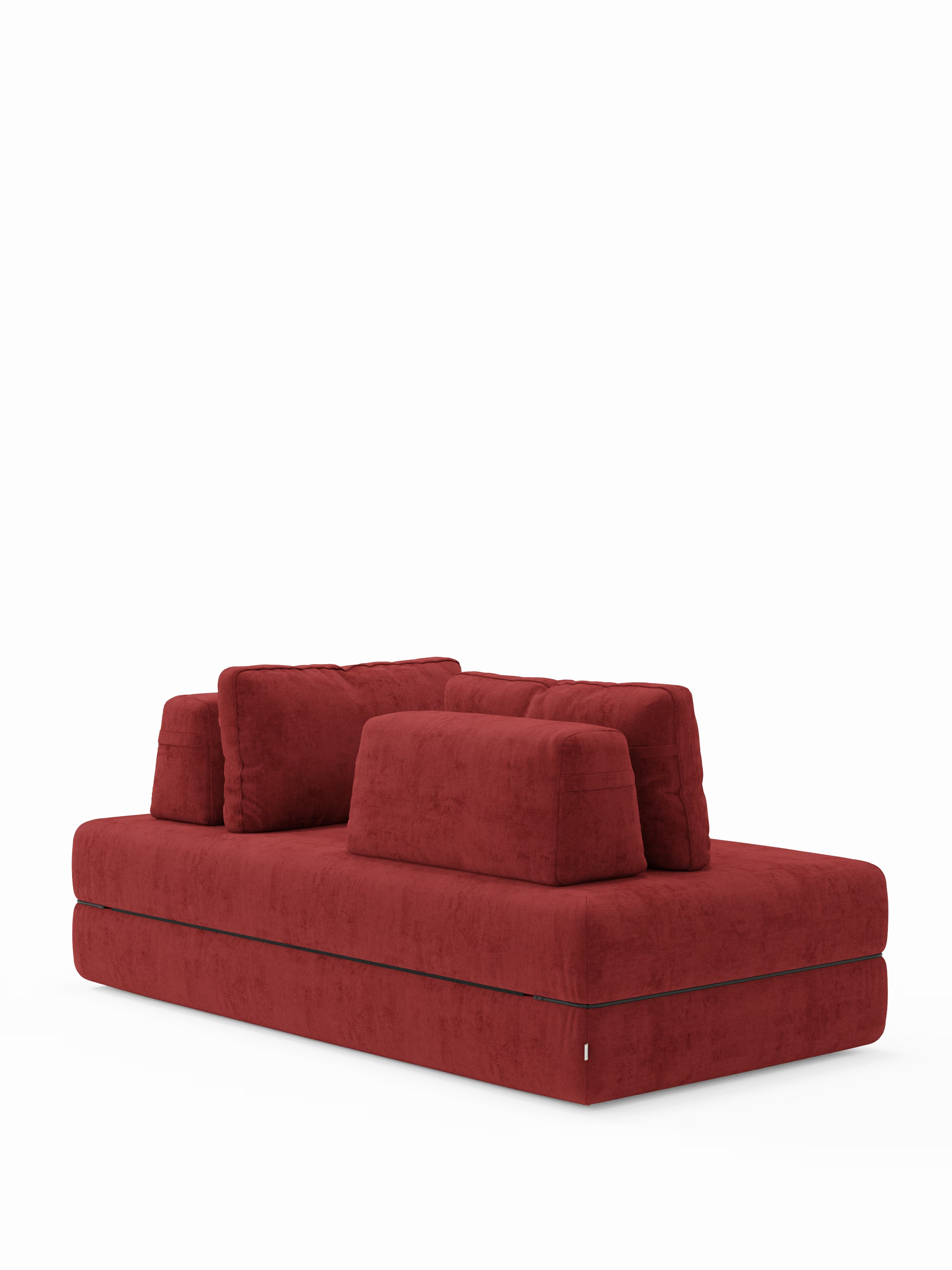 Un moderno divano letto matrimoniale Rift a 2 e 3 posti di Divani.Store in una tonalità di rosso intenso, caratterizzato da morbidi cuscini rettangolari disposti su due file e da un profilo ribassato, che risaltano su uno sfondo bianco a tinta unita. Il rivestimento testurizzato e vellutato ne esalta il design contemporaneo: perfetto per trasformarsi in un letto spazioso e confortevole grazie al materasso in memory foam T31 di alta qualità, dello spessore di 22 cm, e agli schienali regolabili.